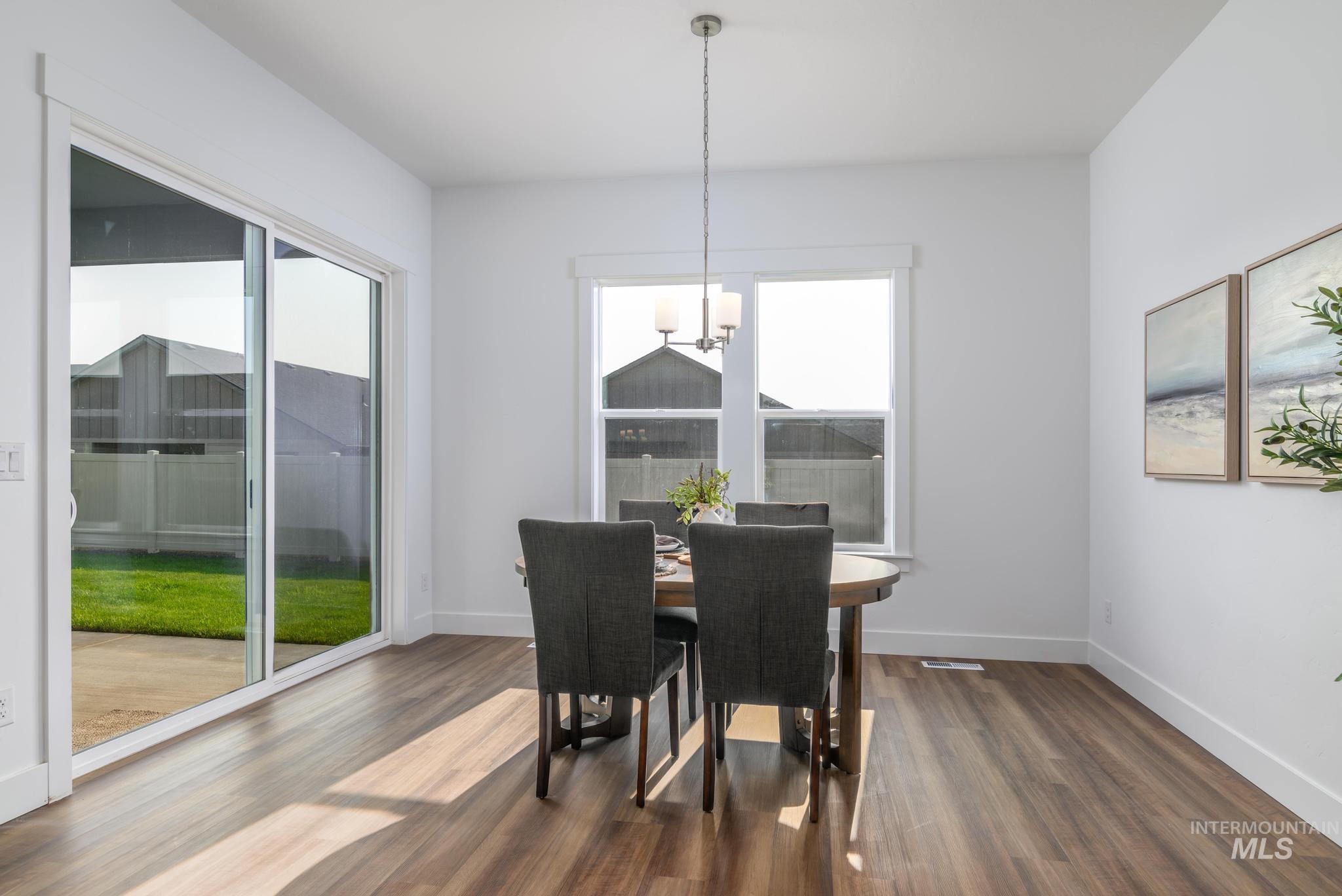 Dining room featuring plenty of natural light, dark wood finished floors, and a chandelier