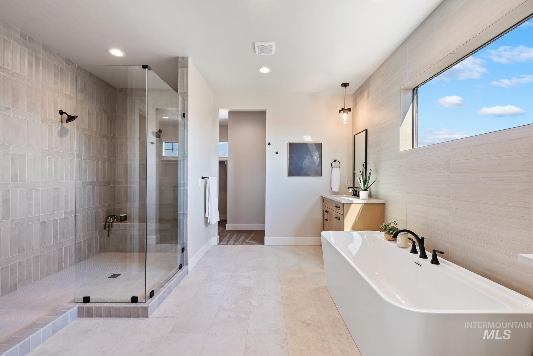 Bathroom with vanity, a stall shower, a freestanding bath, recessed lighting, and light tile patterned flooring