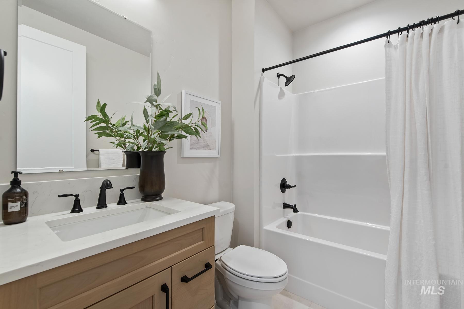 Full bathroom with shower / tub combo with curtain and vanity