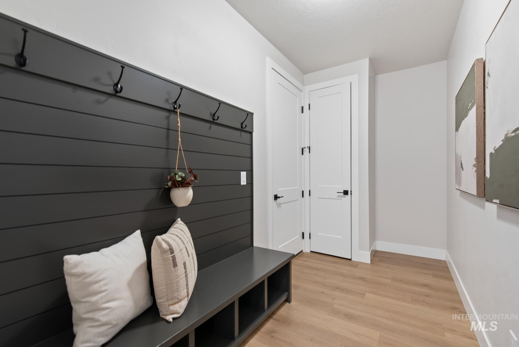Mudroom with light wood finished floors and baseboards
