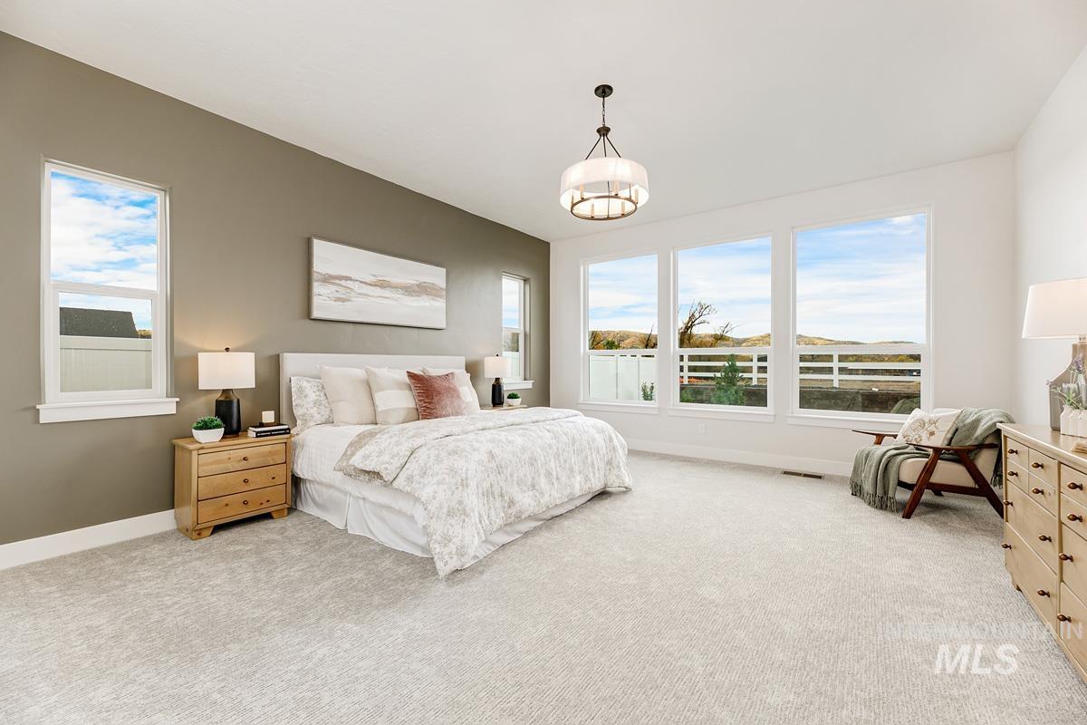 Bedroom with light carpet and multiple windows