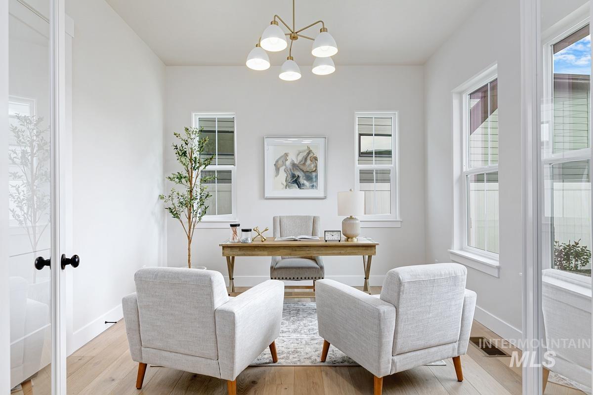 Office space with light wood-style flooring, a chandelier, and french doors