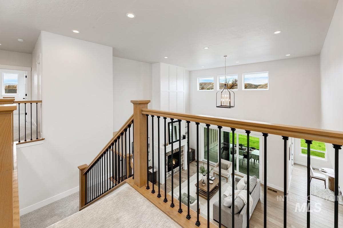 Staircase with recessed lighting, a chandelier, and wood finished floors