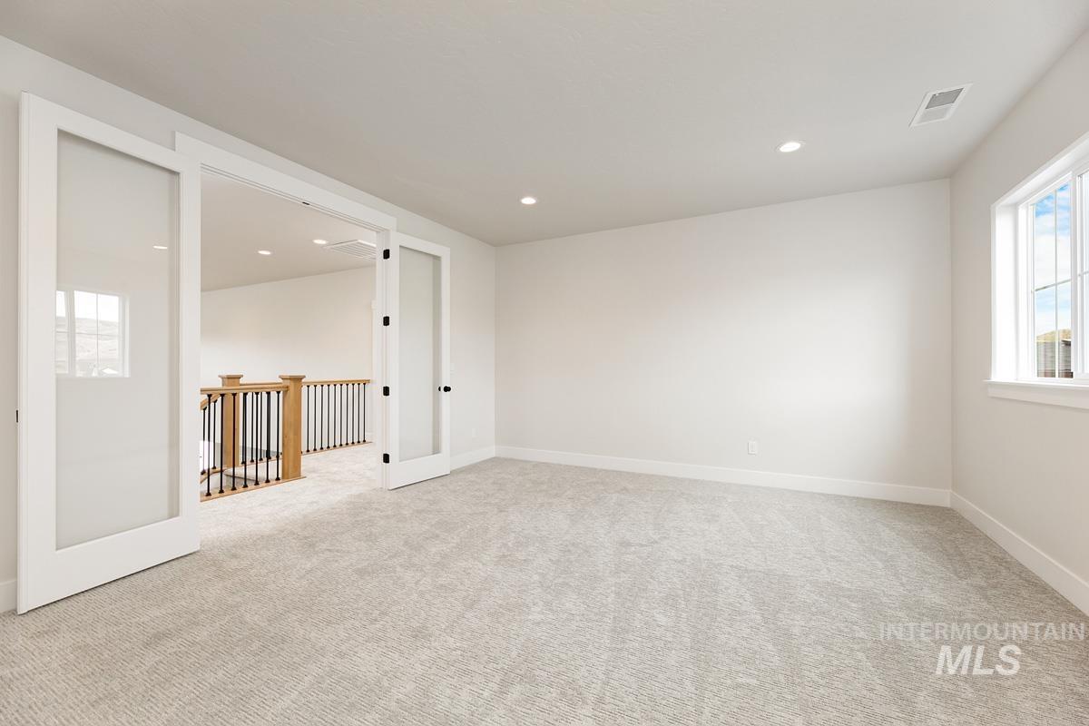 Spare room with light colored carpet and recessed lighting