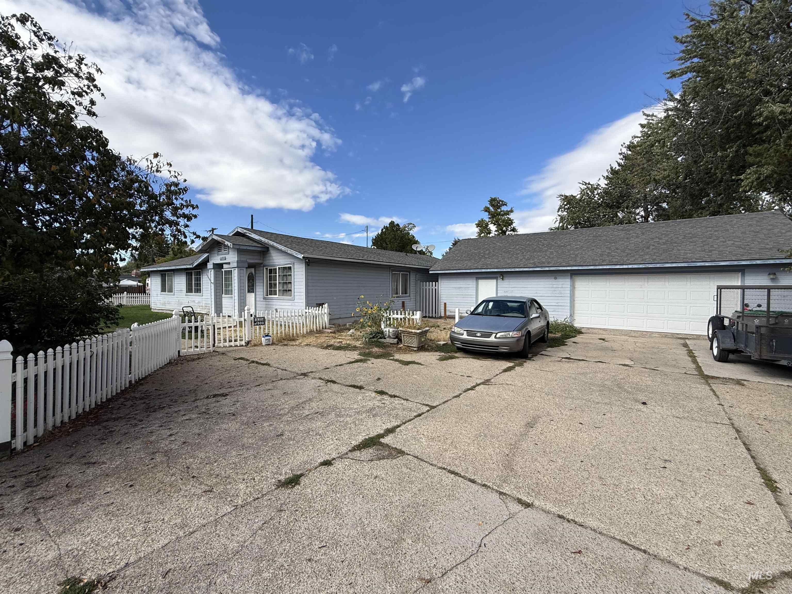 View of front of property with an outdoor structure, a fenced front yard, and a garage