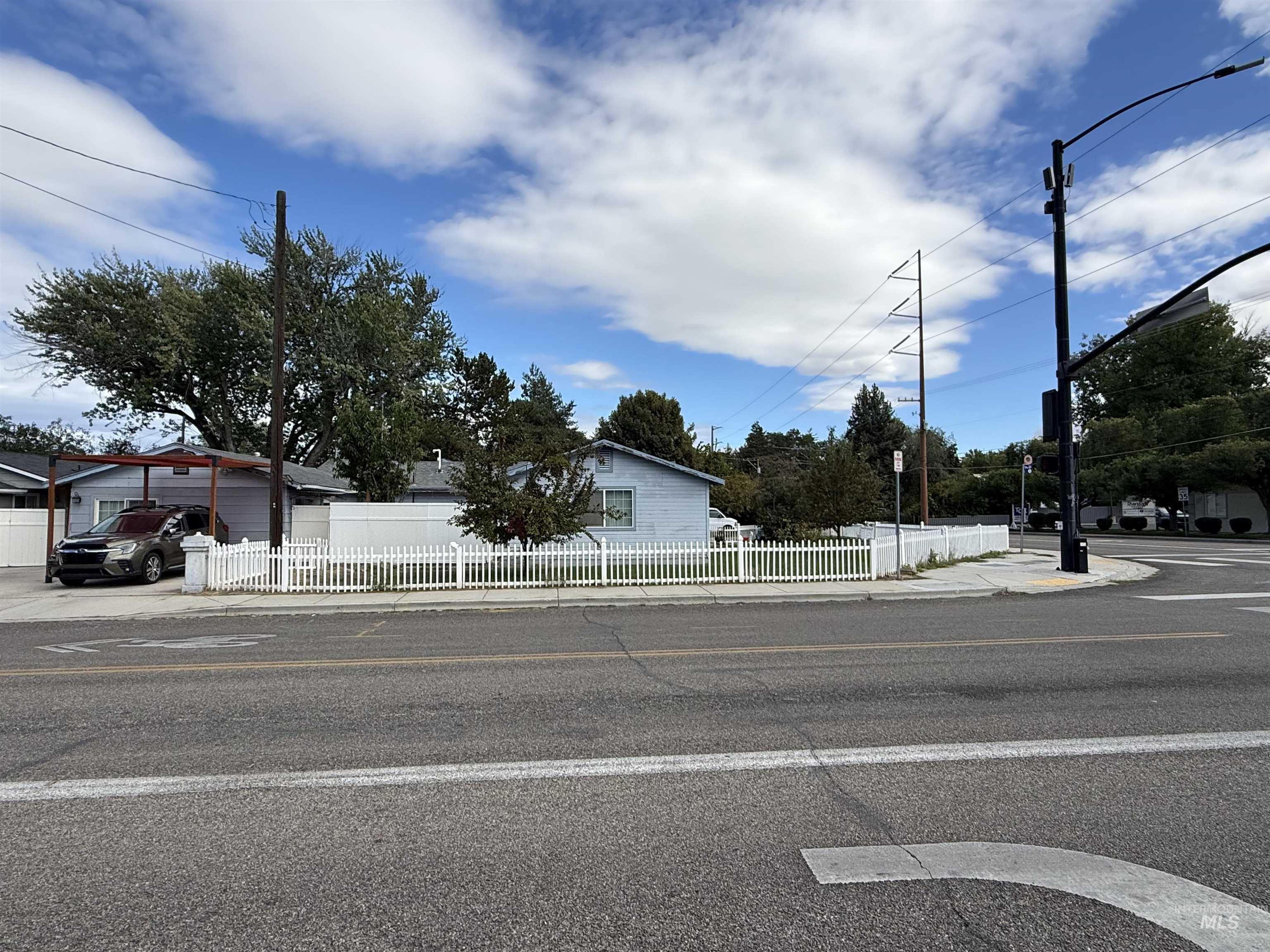 View of asphalt road featuring sidewalks and curbs