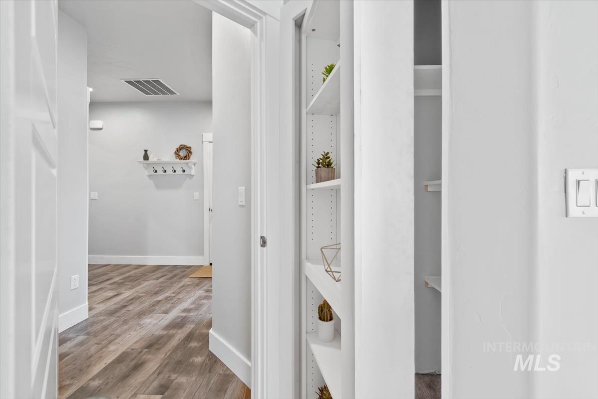 Hall with dark wood-type flooring and baseboards