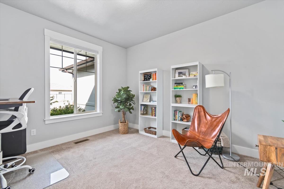 Office space with light colored carpet and baseboards