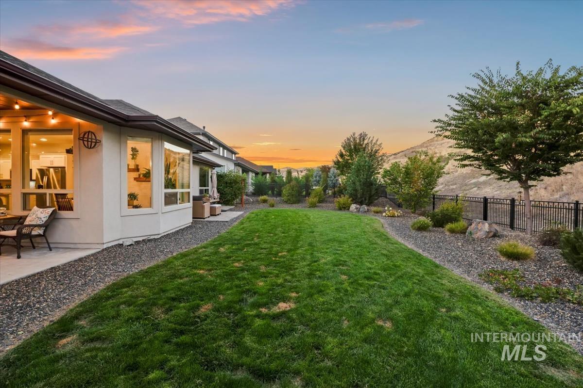 Yard at dusk featuring a fenced backyard and a patio