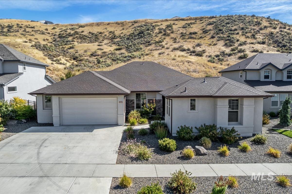 View of front of house featuring concrete driveway, an attached garage, and stucco siding