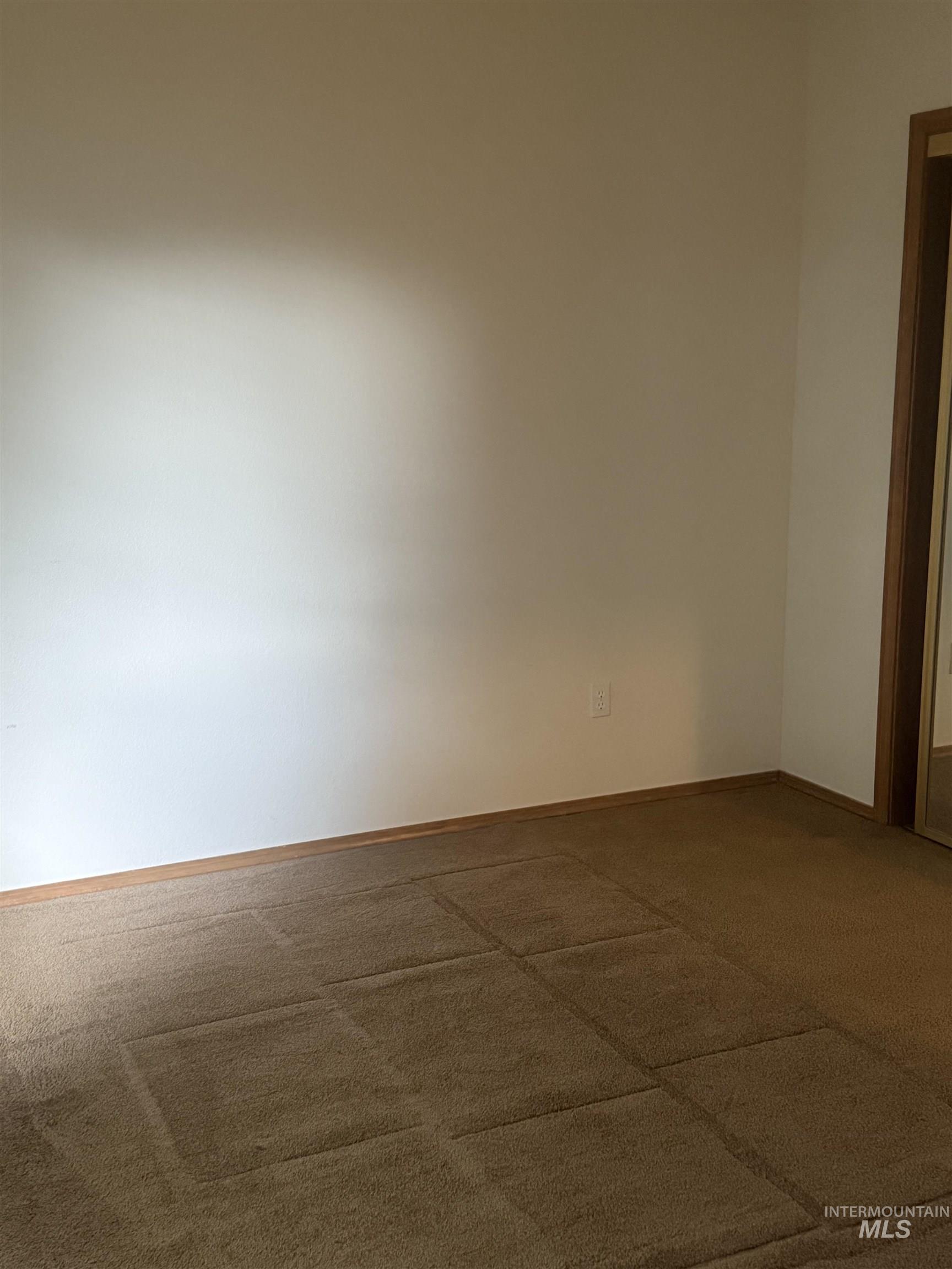 Carpeted empty room with baseboards