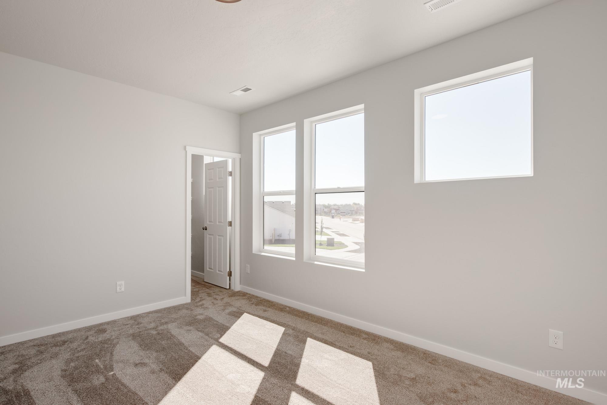 Empty room featuring carpet and baseboards