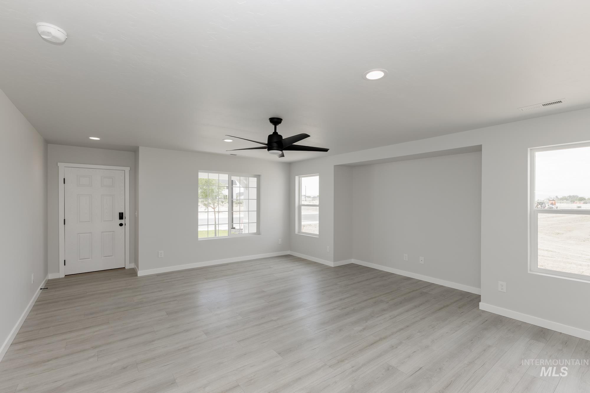 Unfurnished living room featuring light wood-type flooring, ceiling fan, and recessed lighting