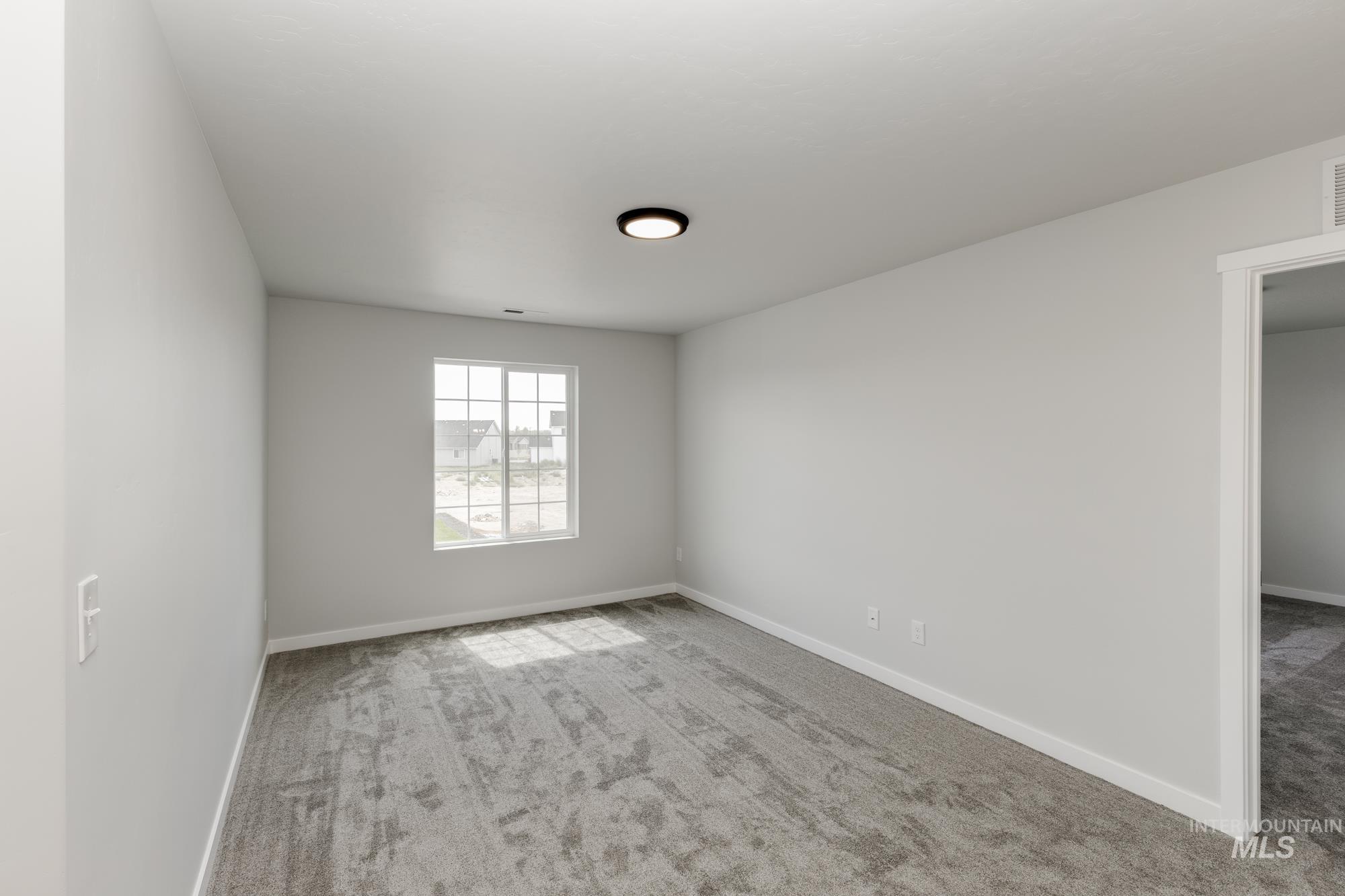 Empty room featuring light carpet and baseboards