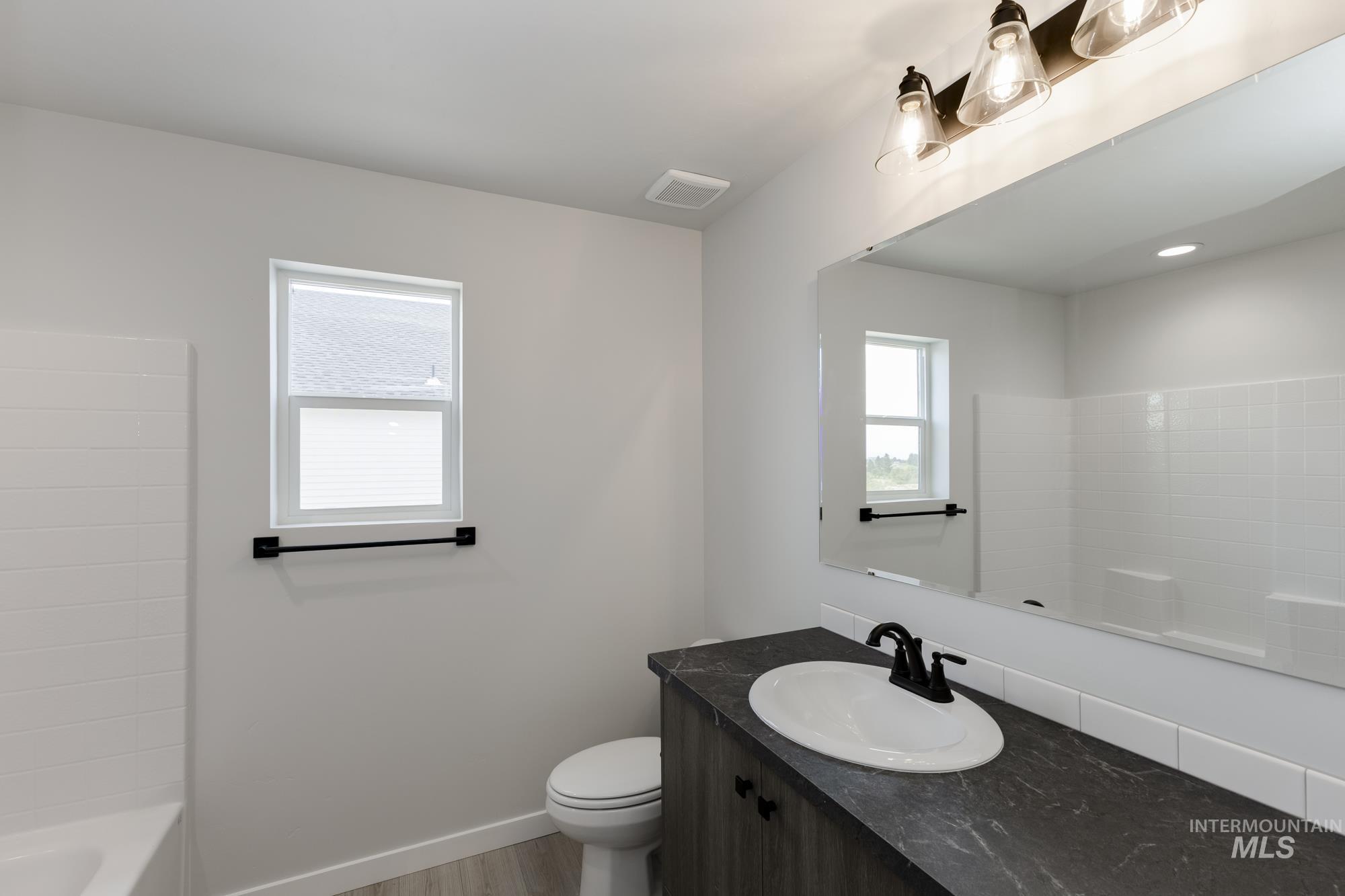 Full bath featuring vanity, light wood-style flooring, and shower / bathtub combination