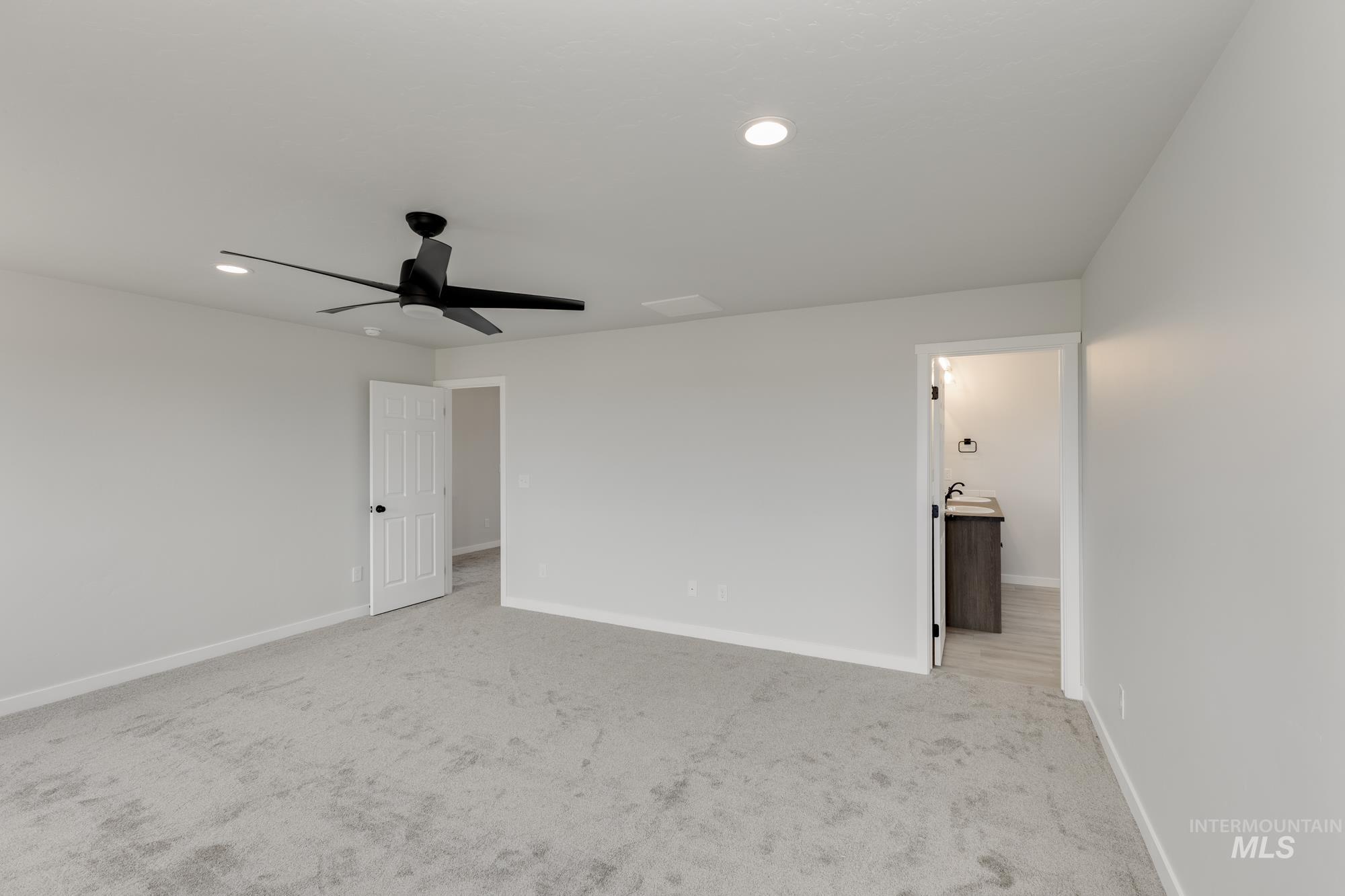 Unfurnished bedroom featuring carpet, recessed lighting, ceiling fan, and ensuite bathroom