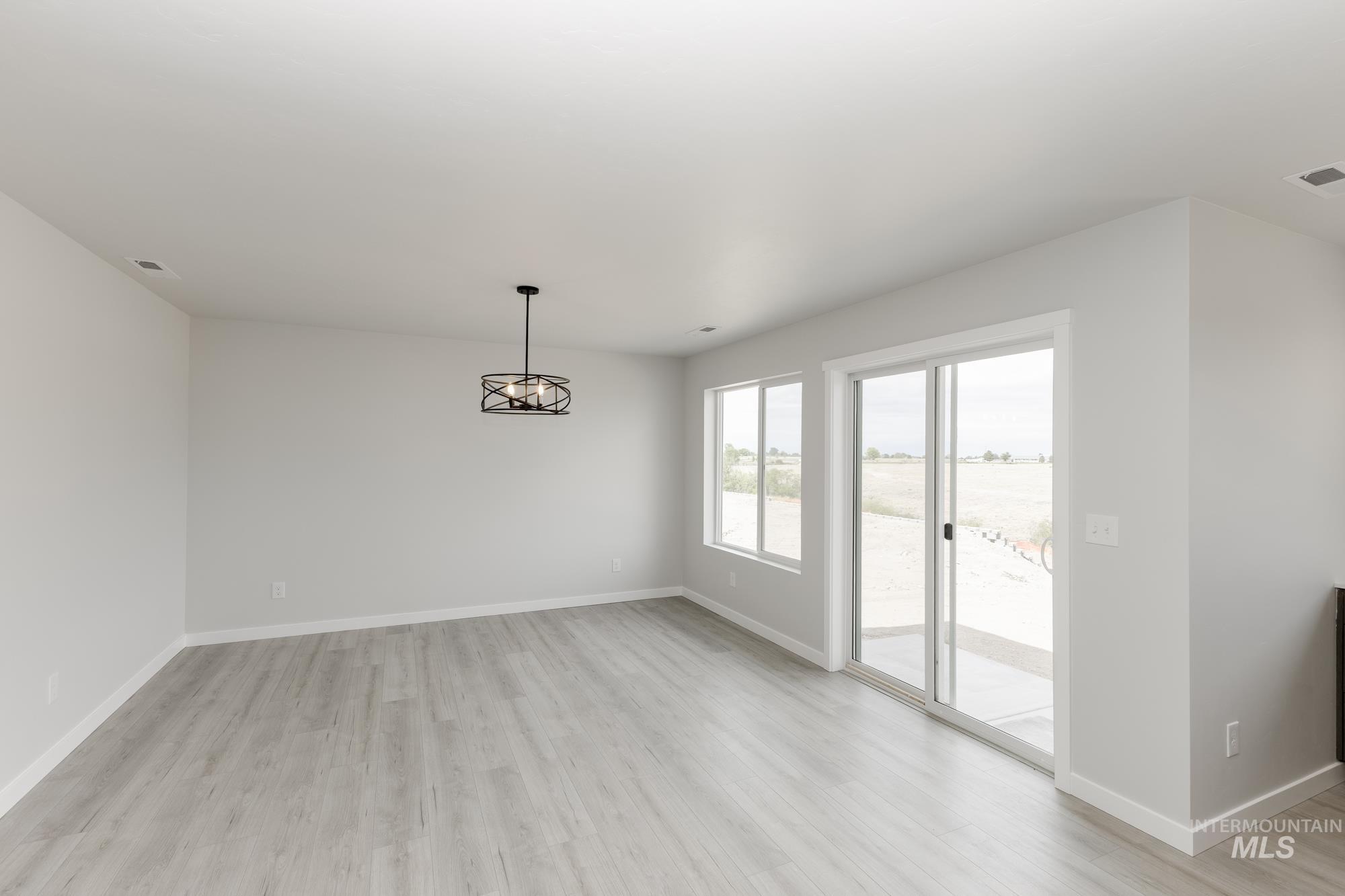 Unfurnished dining area with light wood-style floors and a chandelier