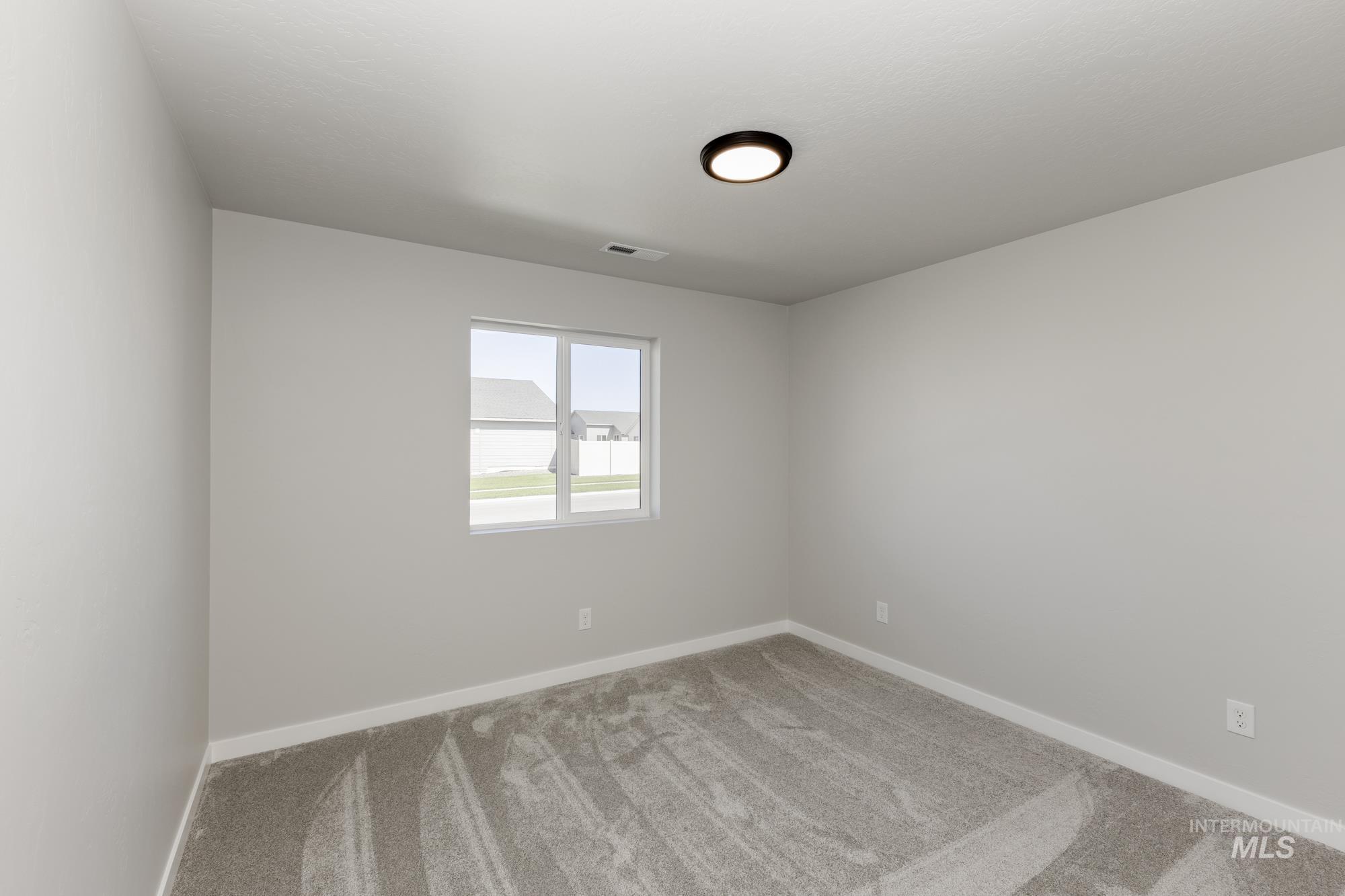 Carpeted empty room featuring baseboards