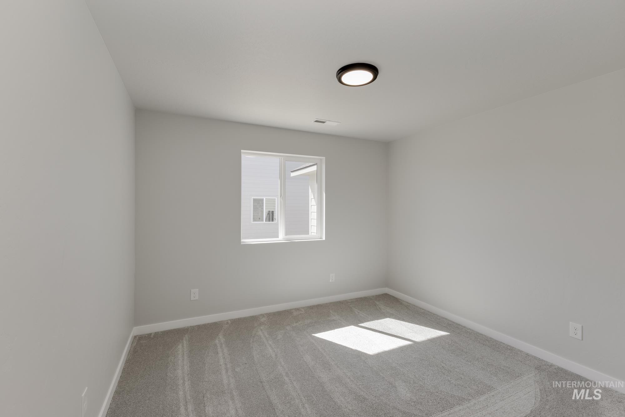 Spare room featuring carpet and baseboards