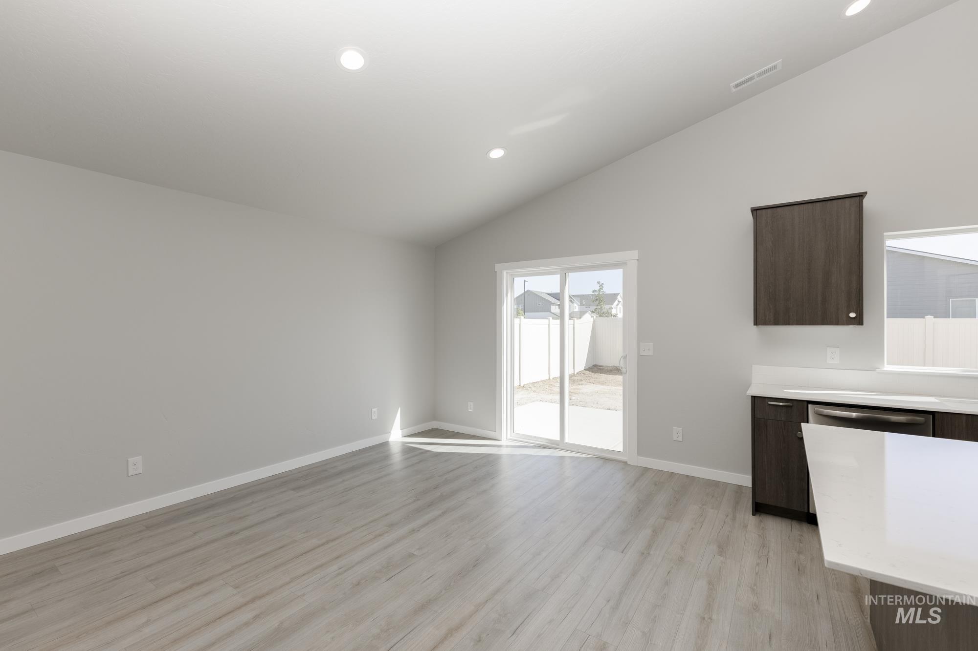 Unfurnished dining area with light wood-type flooring, recessed lighting, and vaulted ceiling