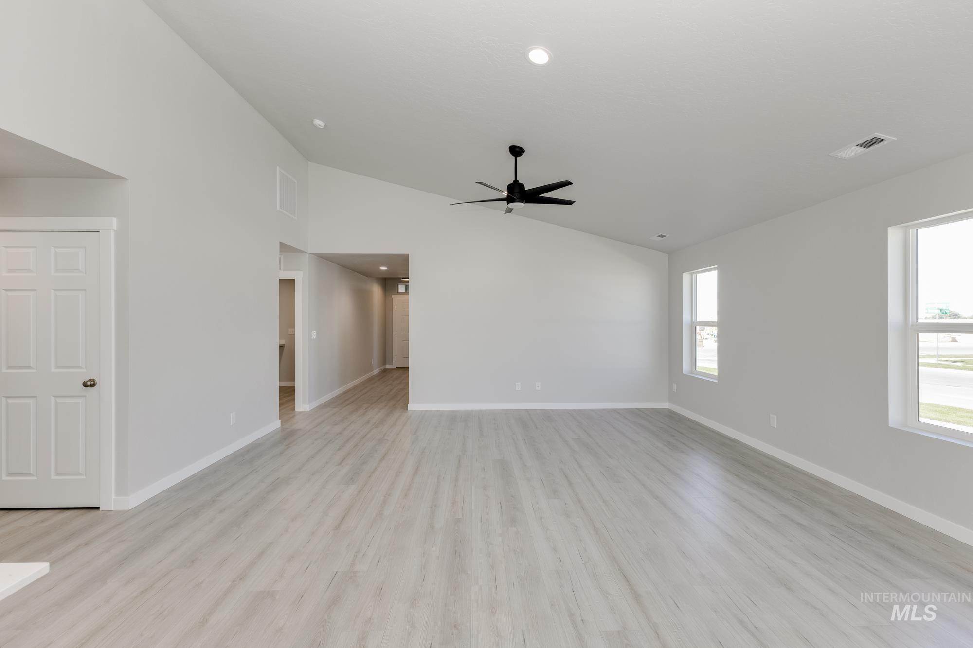 Unfurnished living room with light wood finished floors, recessed lighting, ceiling fan, and high vaulted ceiling