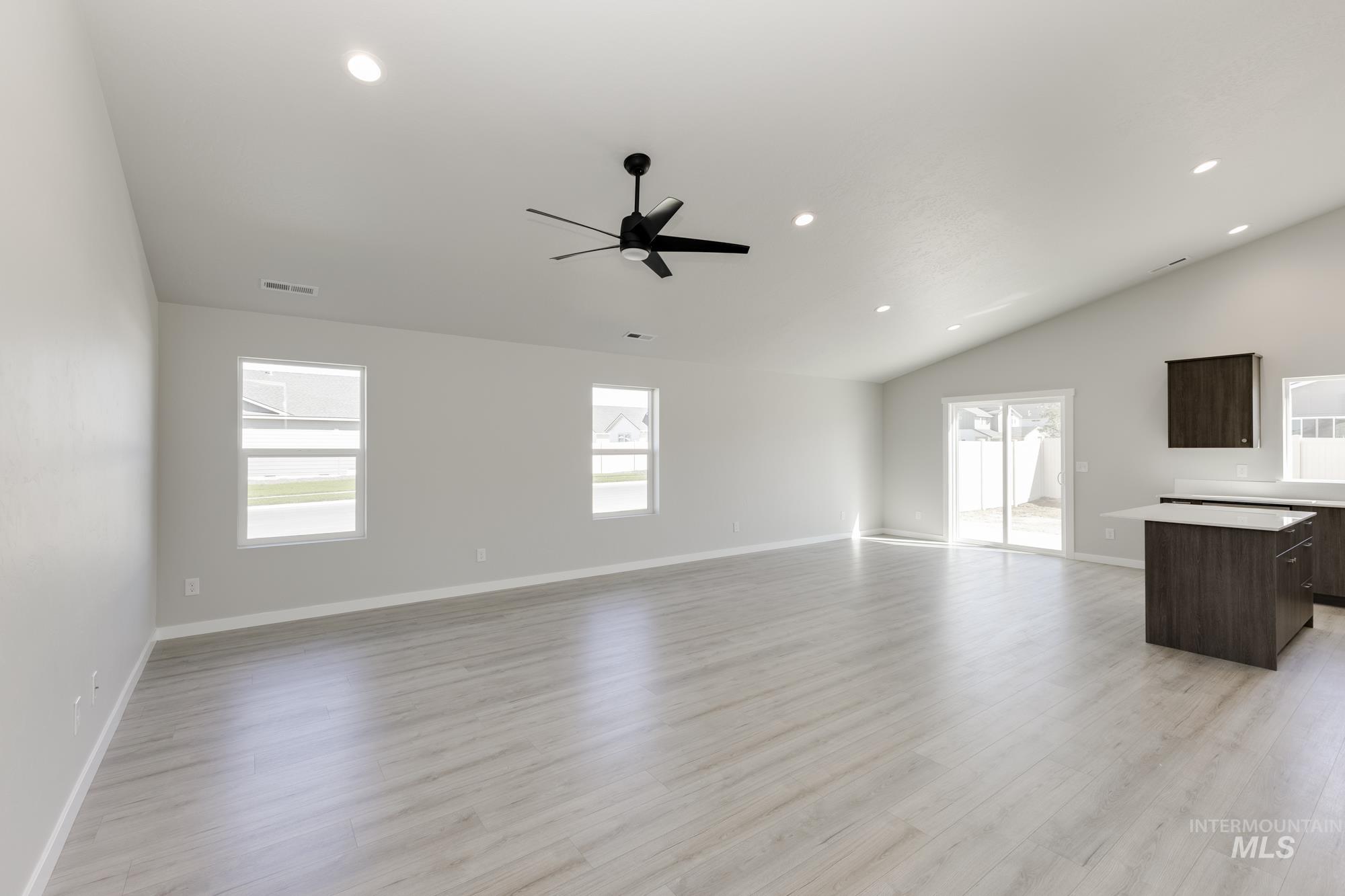 Unfurnished living room featuring light wood-type flooring, recessed lighting, lofted ceiling, and a ceiling fan