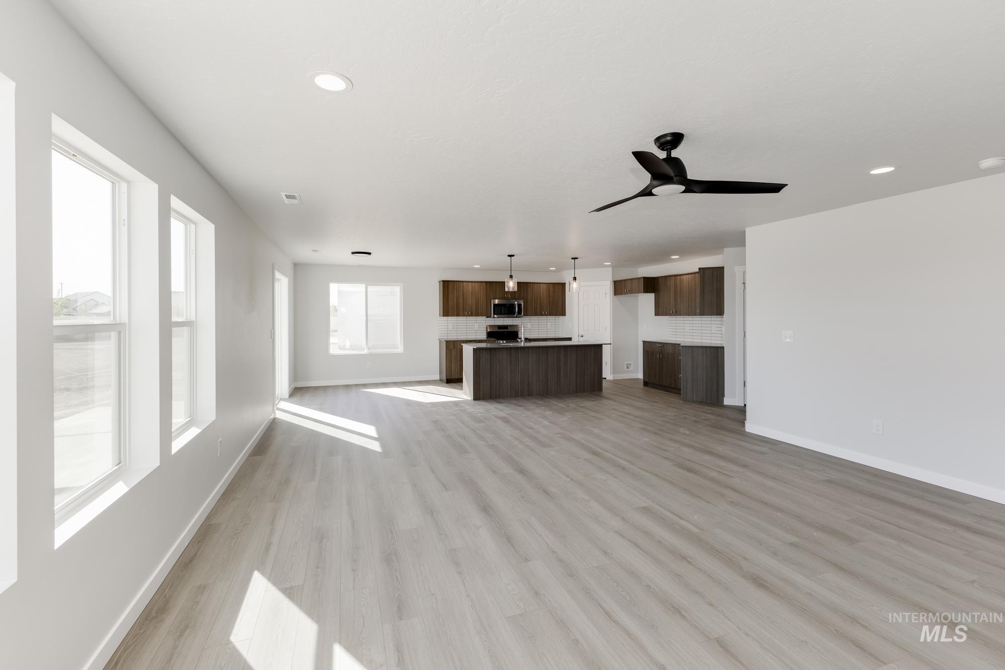 Unfurnished living room with light wood-type flooring, recessed lighting, and ceiling fan