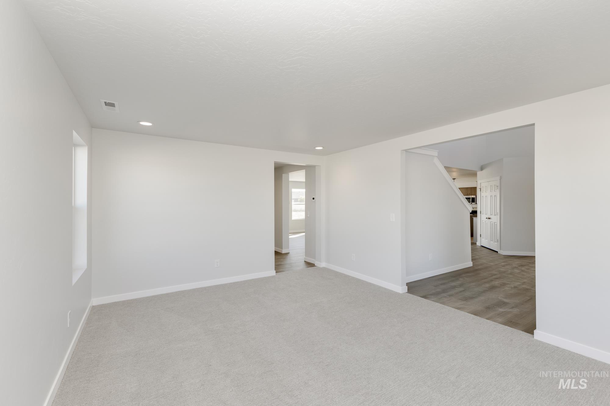 Unfurnished room with light carpet, plenty of natural light, and recessed lighting