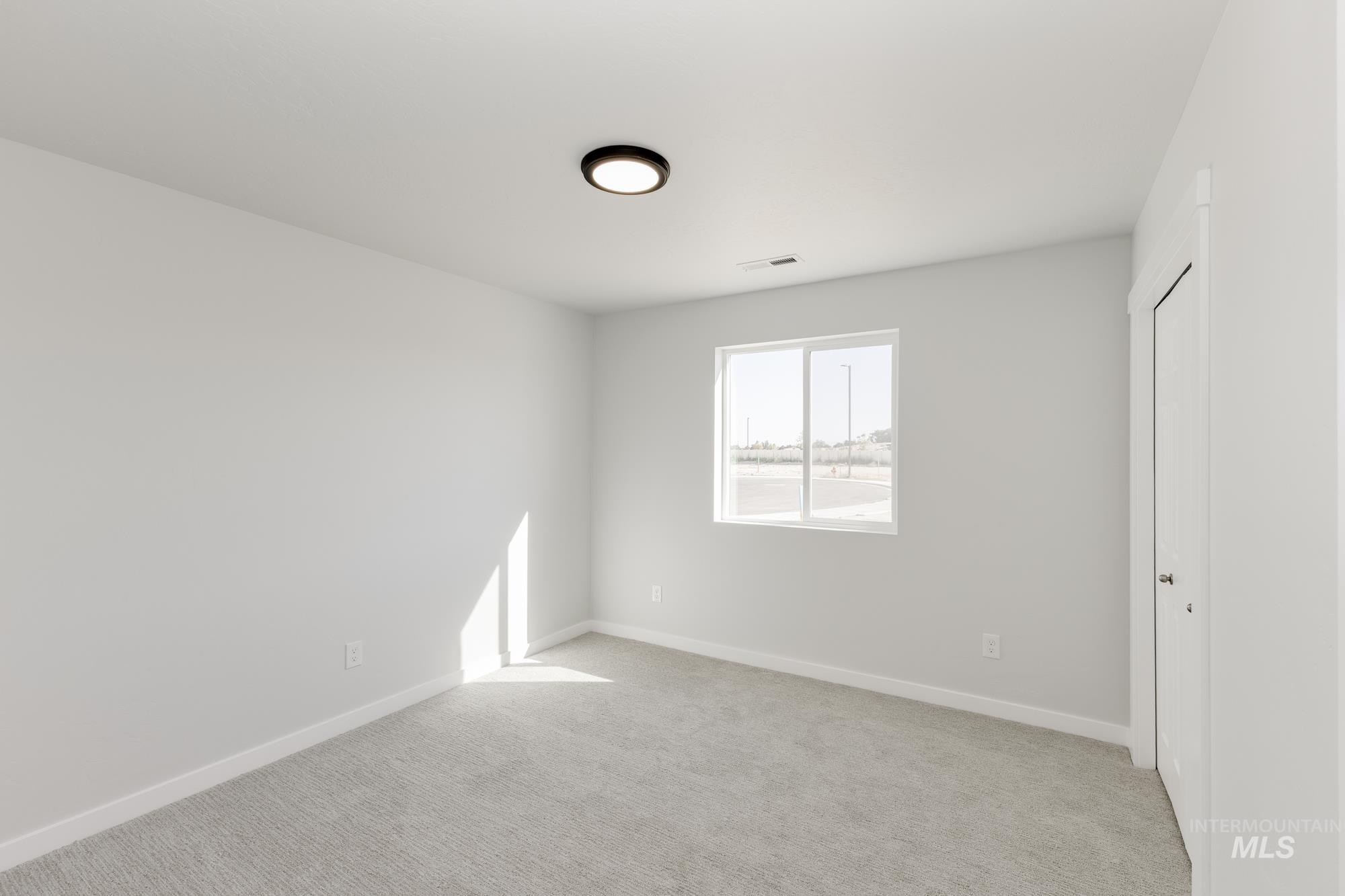 Unfurnished bedroom featuring light carpet and a closet