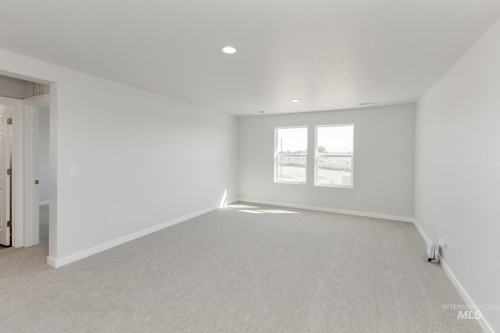 Unfurnished room with light colored carpet and recessed lighting