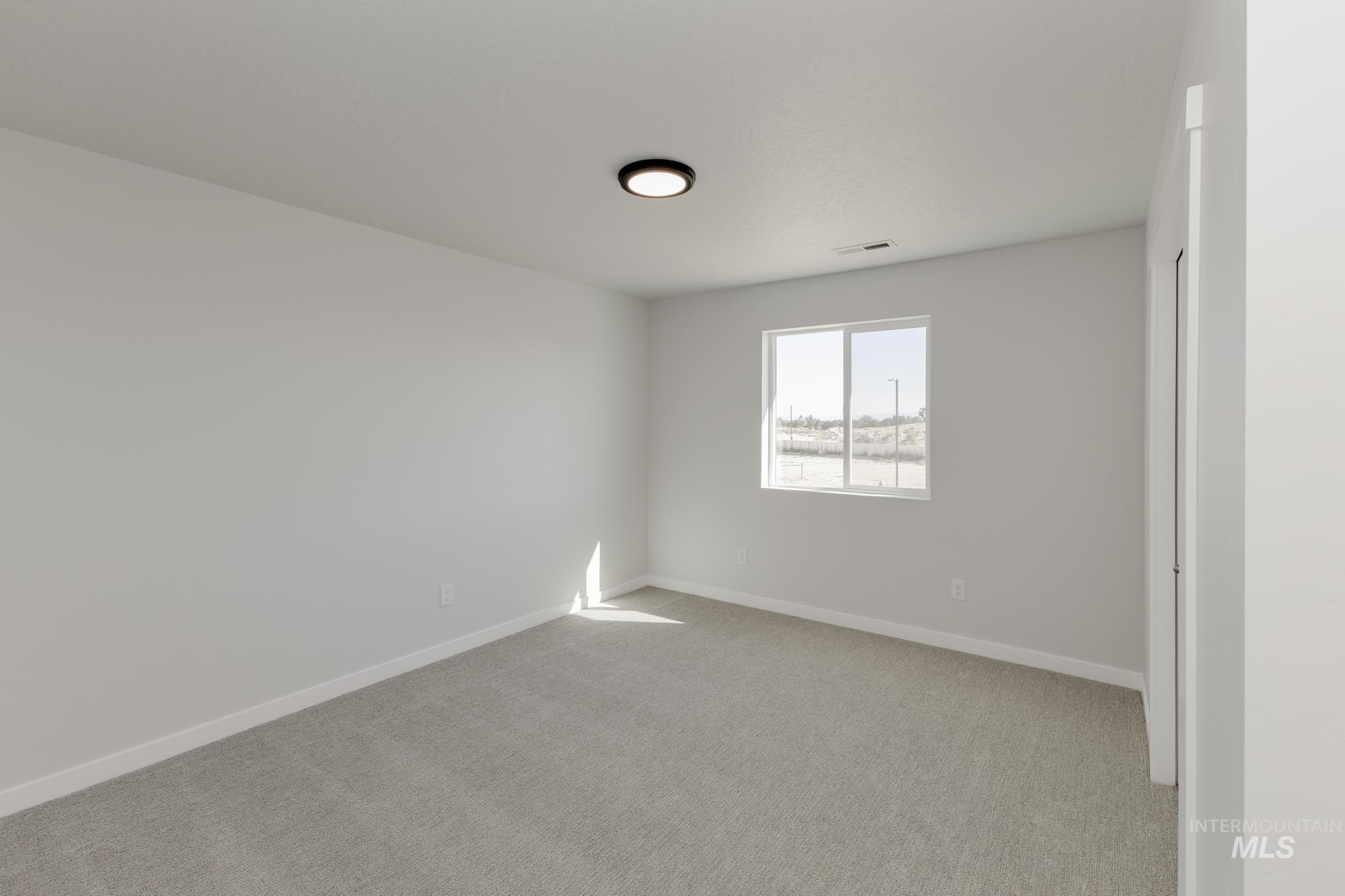 Empty room featuring baseboards and light colored carpet