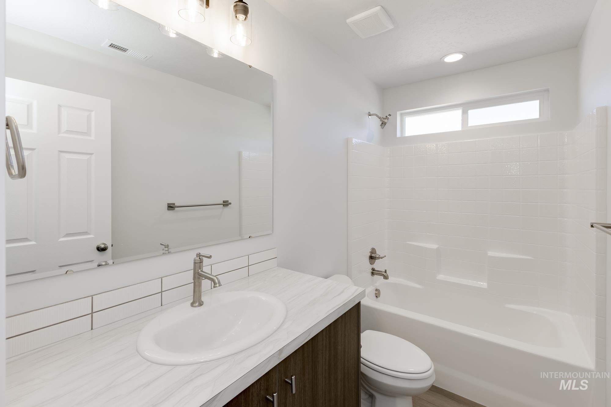 Full bathroom with shower / washtub combination, vanity, and recessed lighting