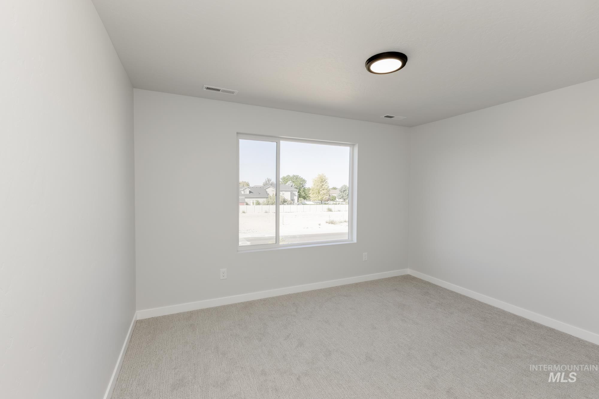Empty room featuring light colored carpet