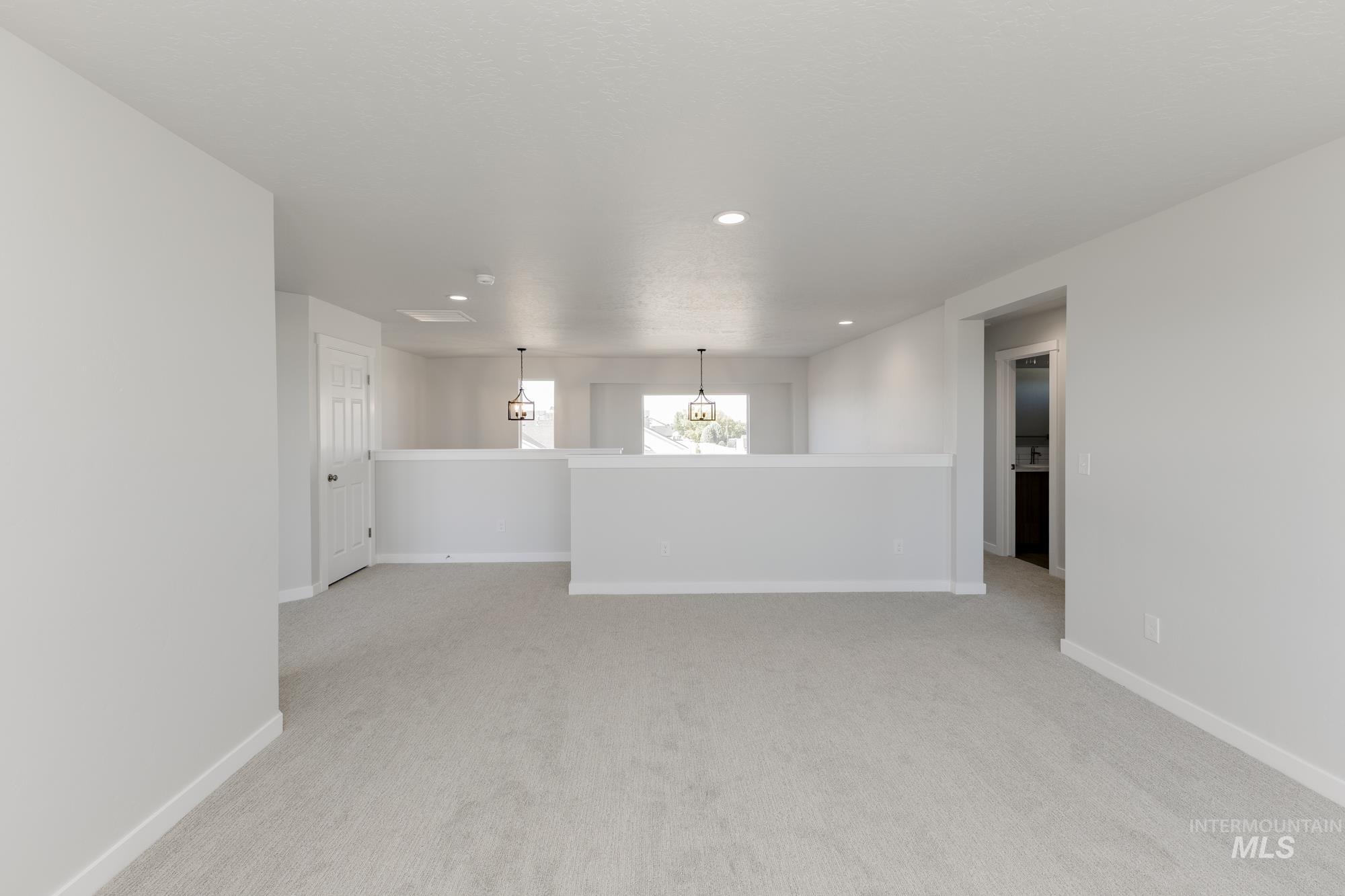 Spare room with light colored carpet, recessed lighting, and a chandelier