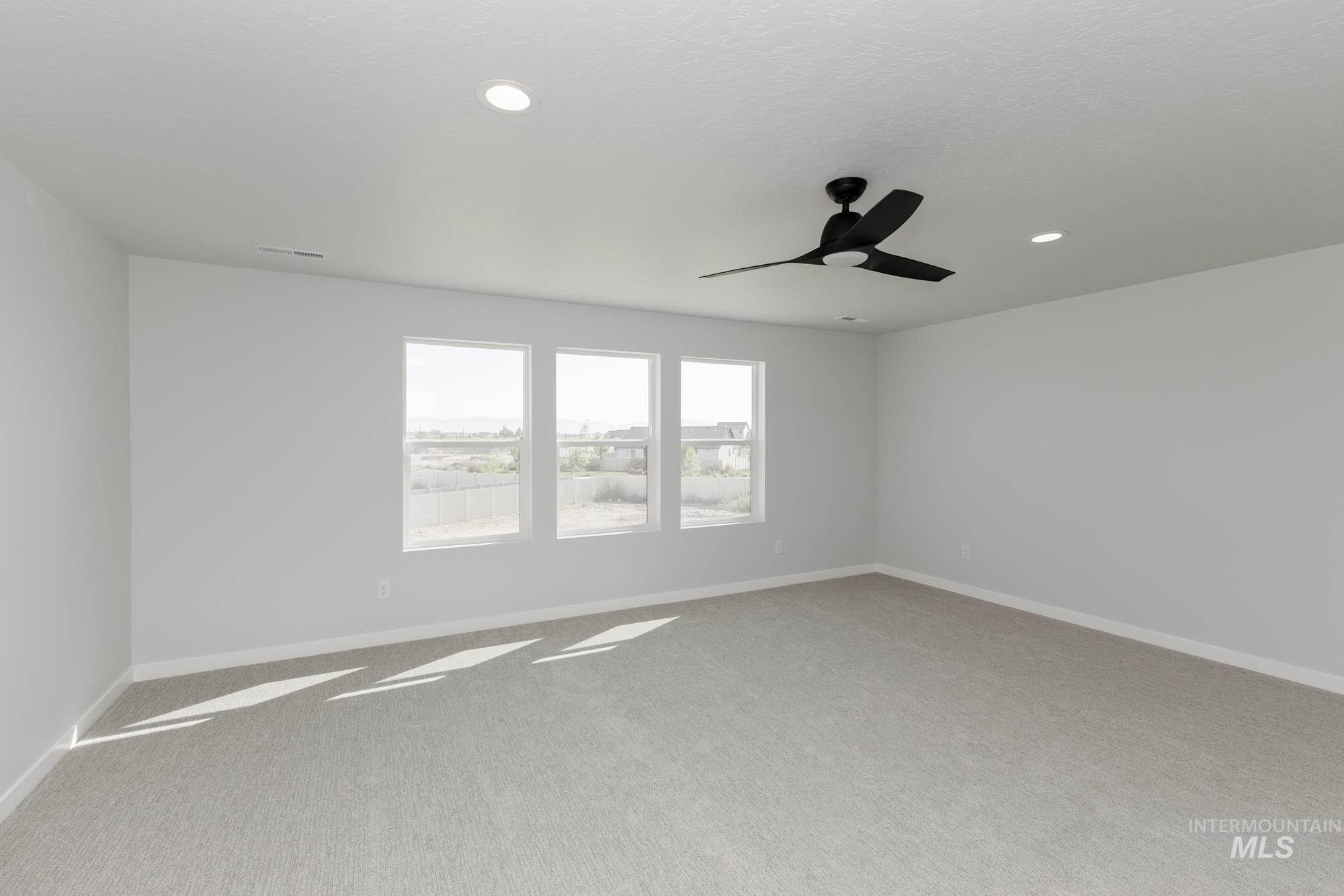 Carpeted spare room featuring a ceiling fan and recessed lighting