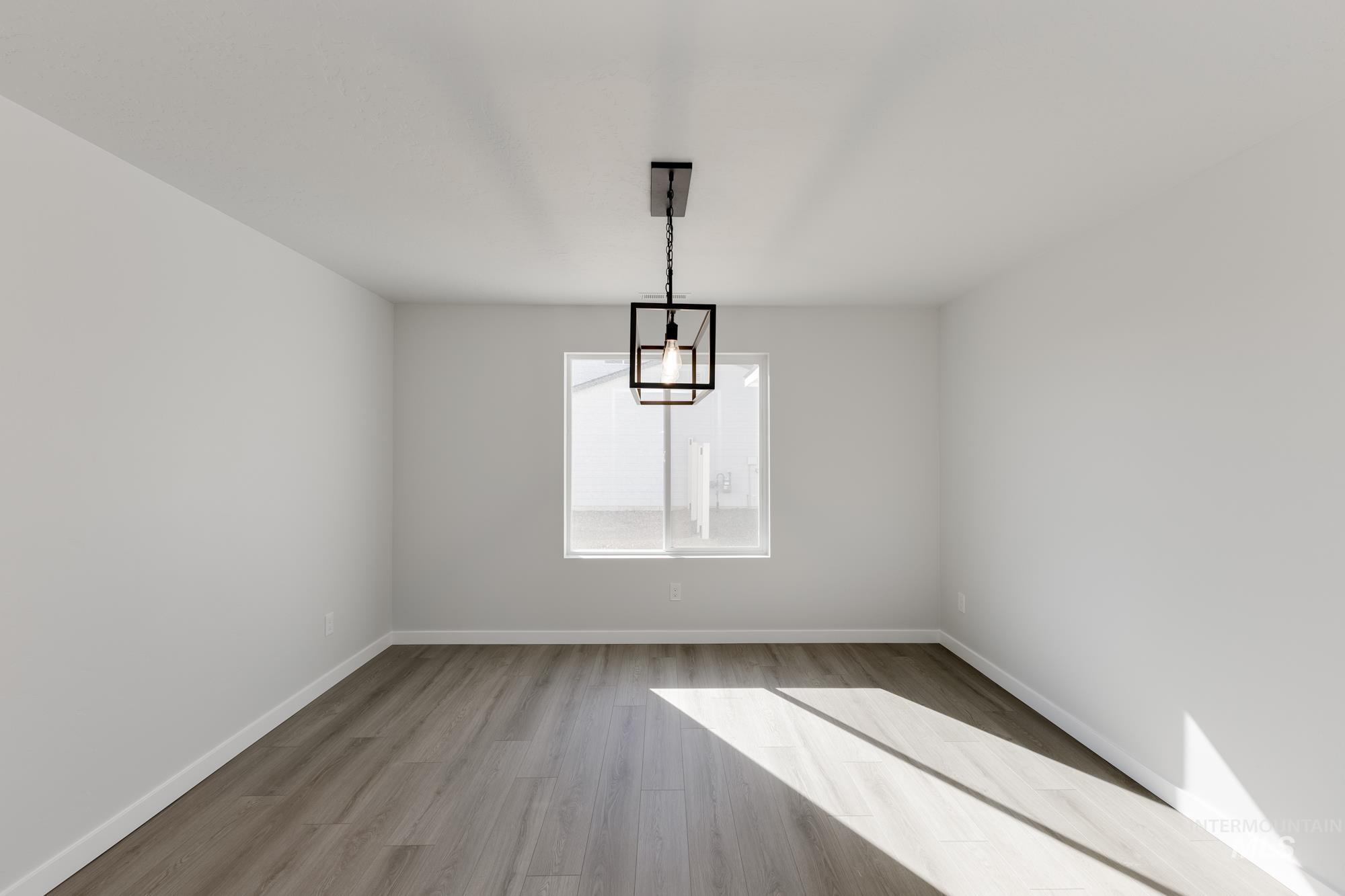 Unfurnished dining area featuring light wood-type flooring and baseboards