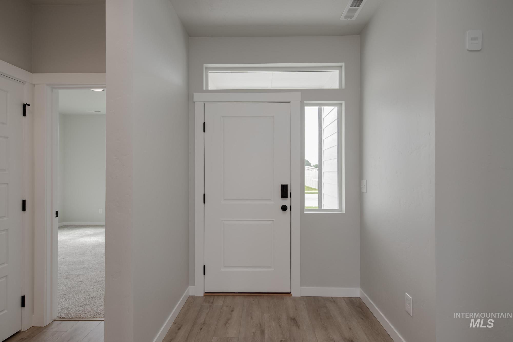 Foyer with baseboards and light wood finished floors