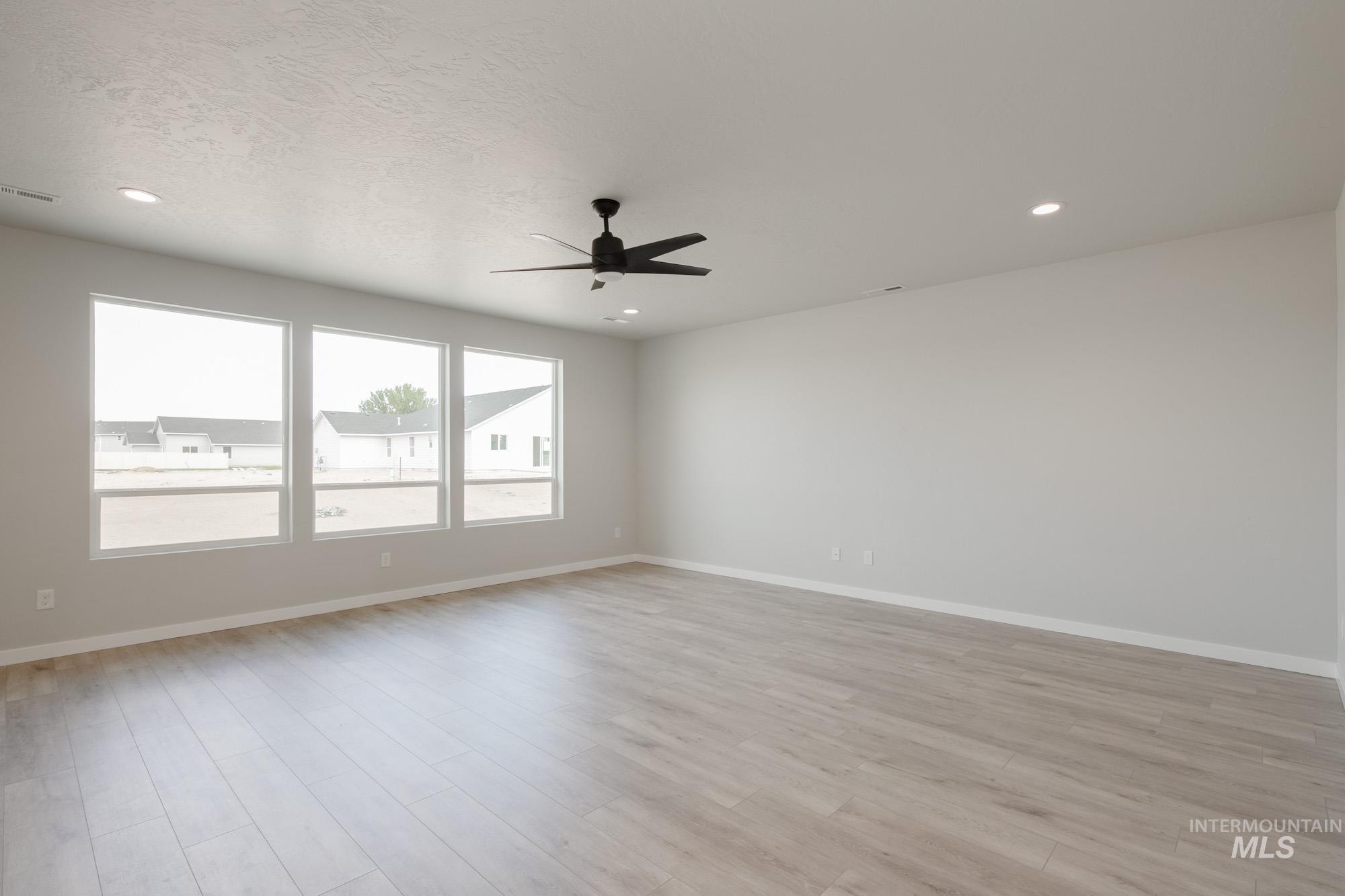 Empty room featuring light wood finished floors, recessed lighting, and ceiling fan