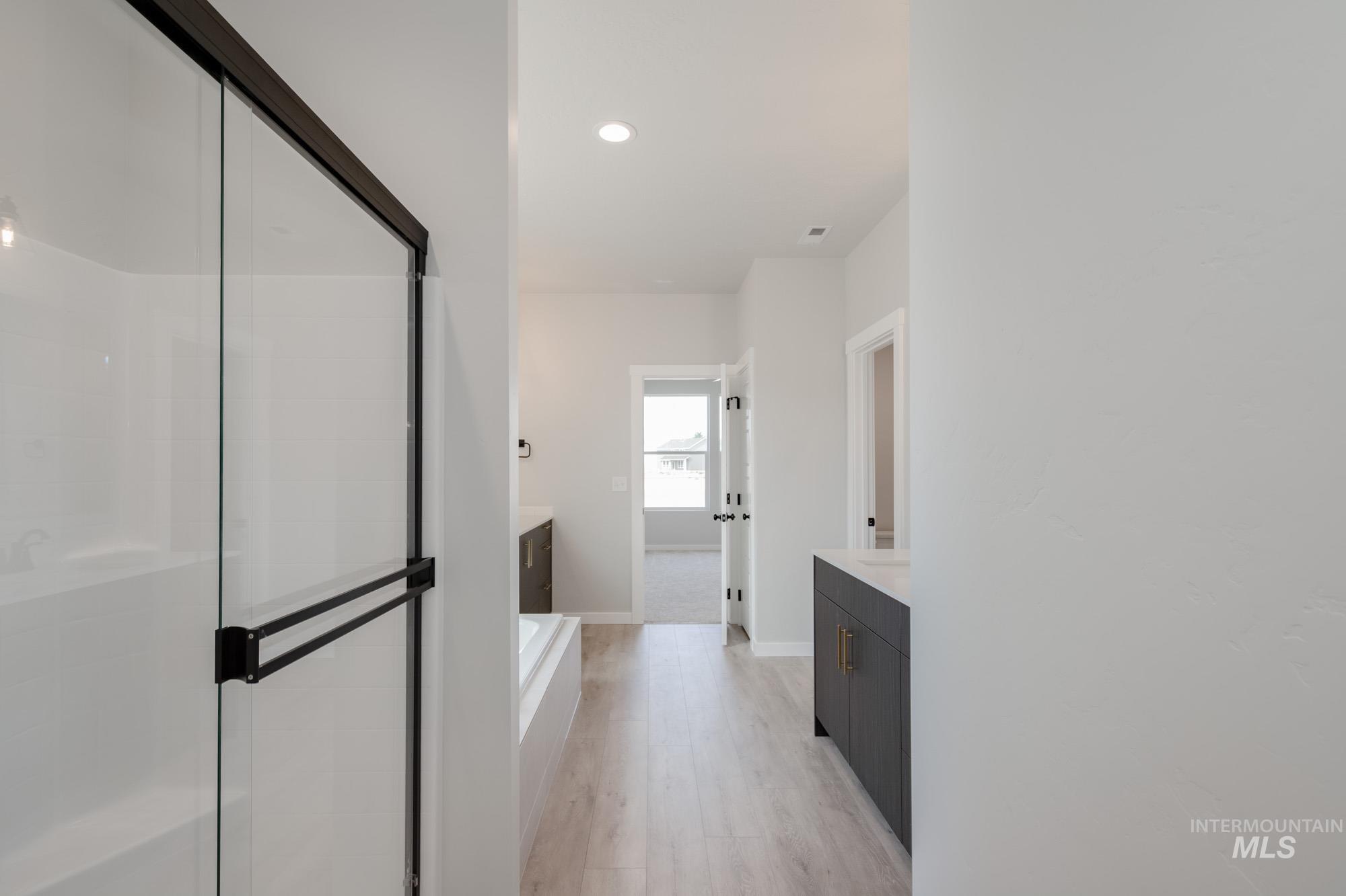 Full bathroom with vanity, a stall shower, recessed lighting, light wood-style floors, and a bath