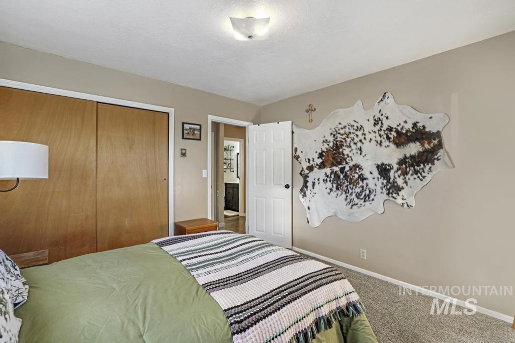 Carpeted bedroom with a closet and a textured ceiling