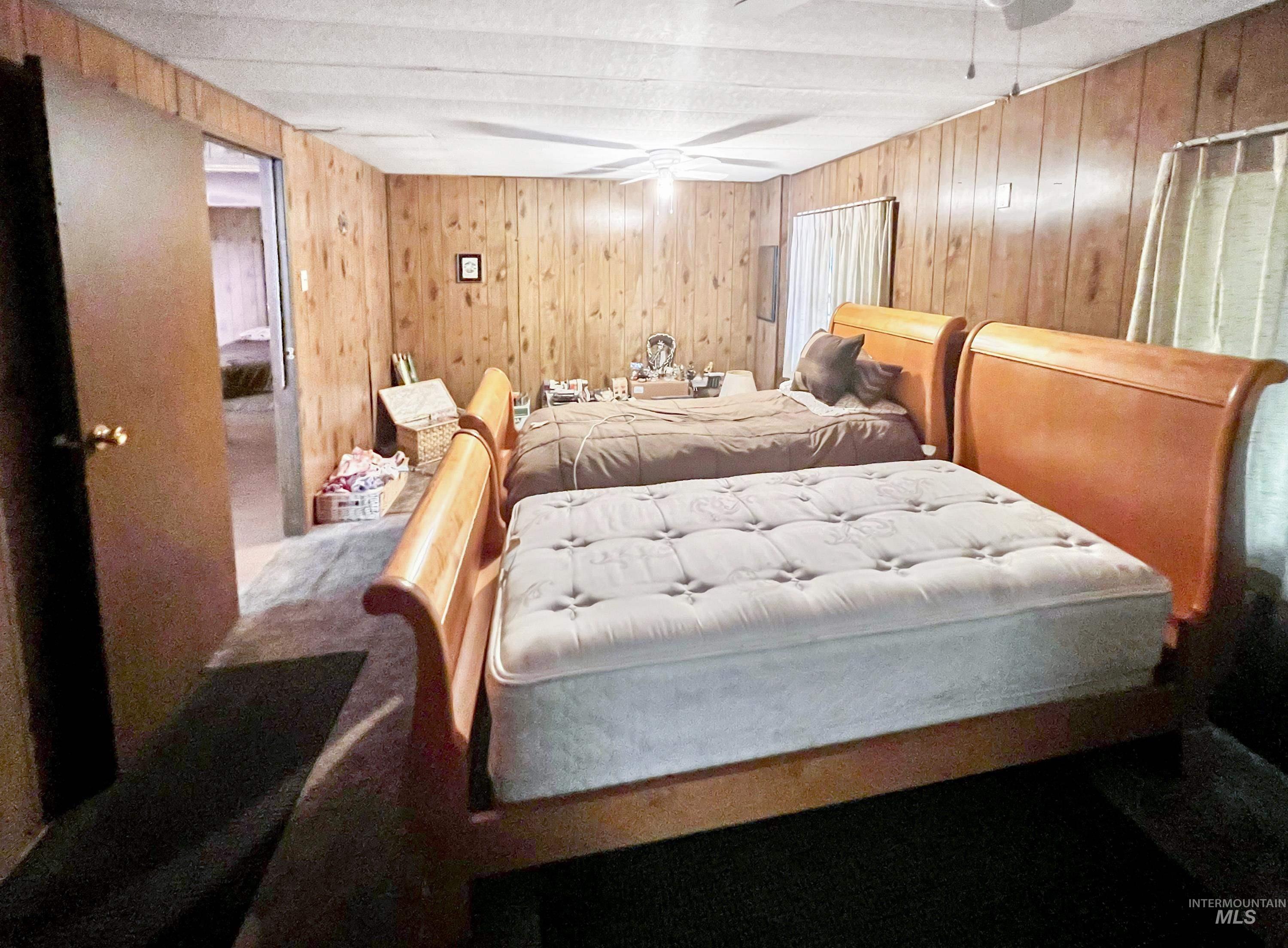 Bedroom with wooden walls and carpet flooring