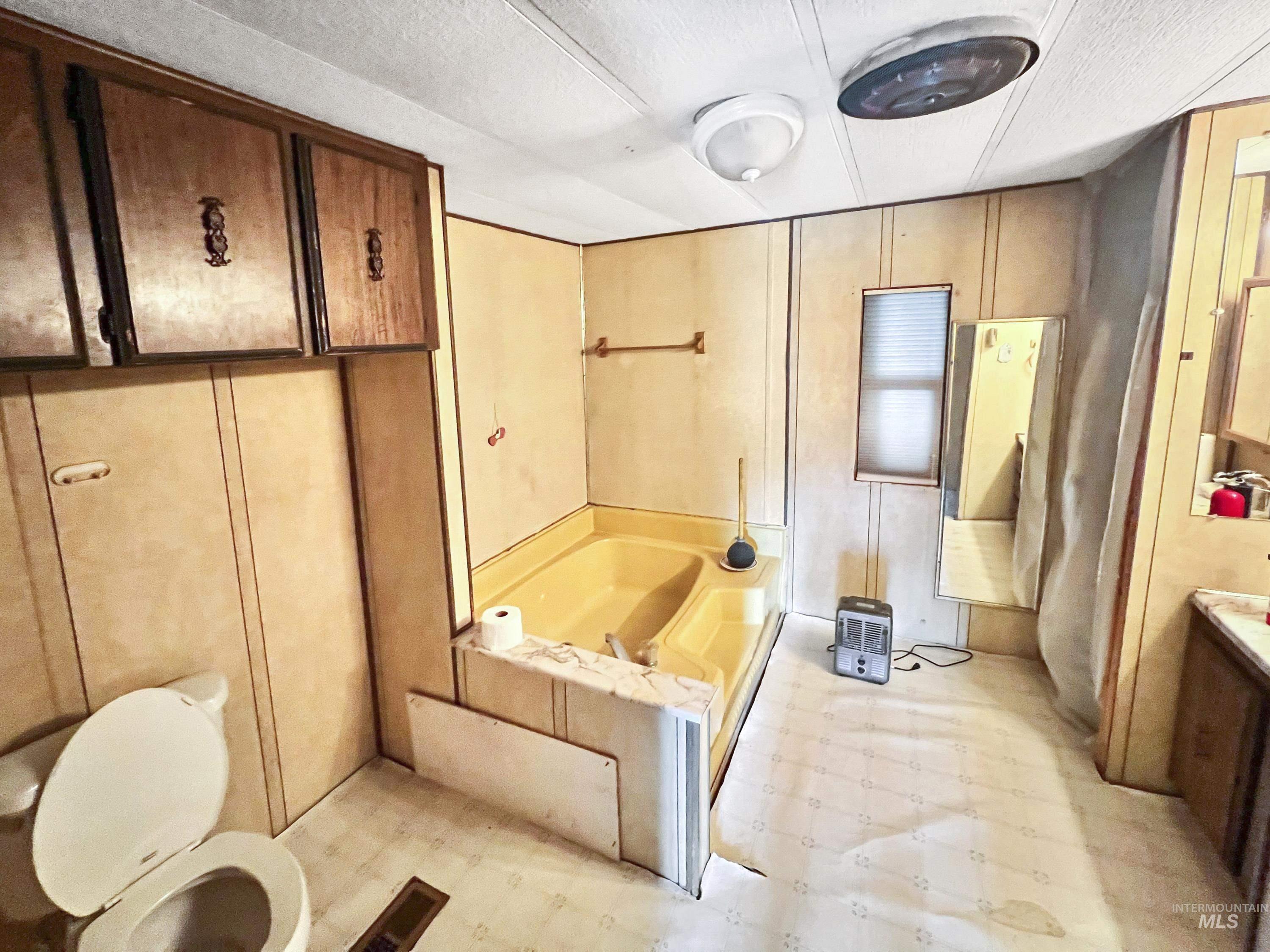 Full bath with light floors, a bath, and vanity
