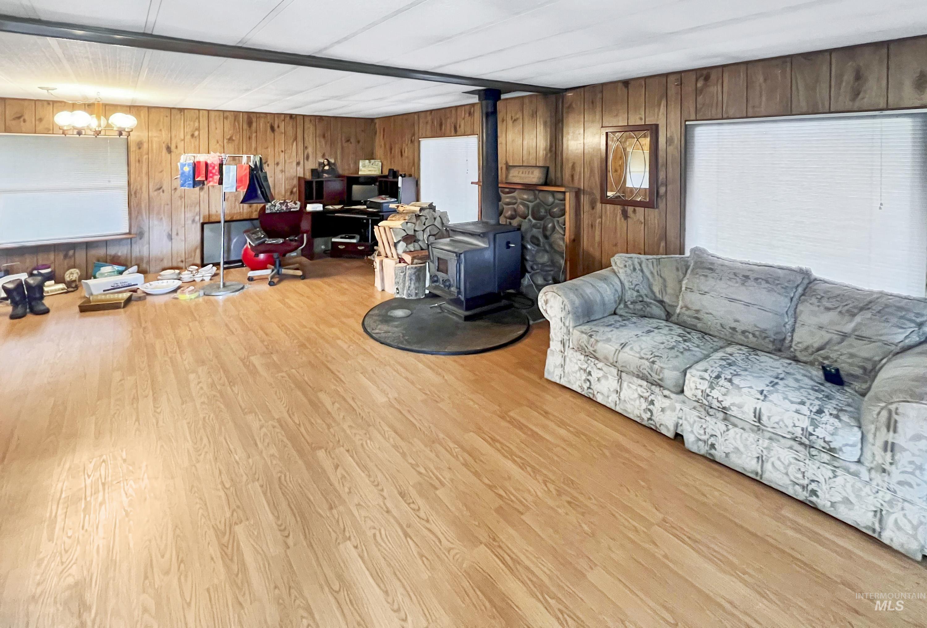 Living area featuring a wood stove, wood walls, and wood finished floors