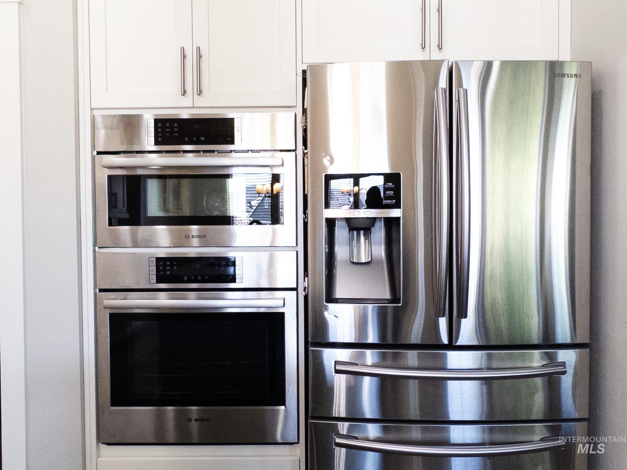 Kitchen featuring appliances with stainless steel finishes and white cabinets