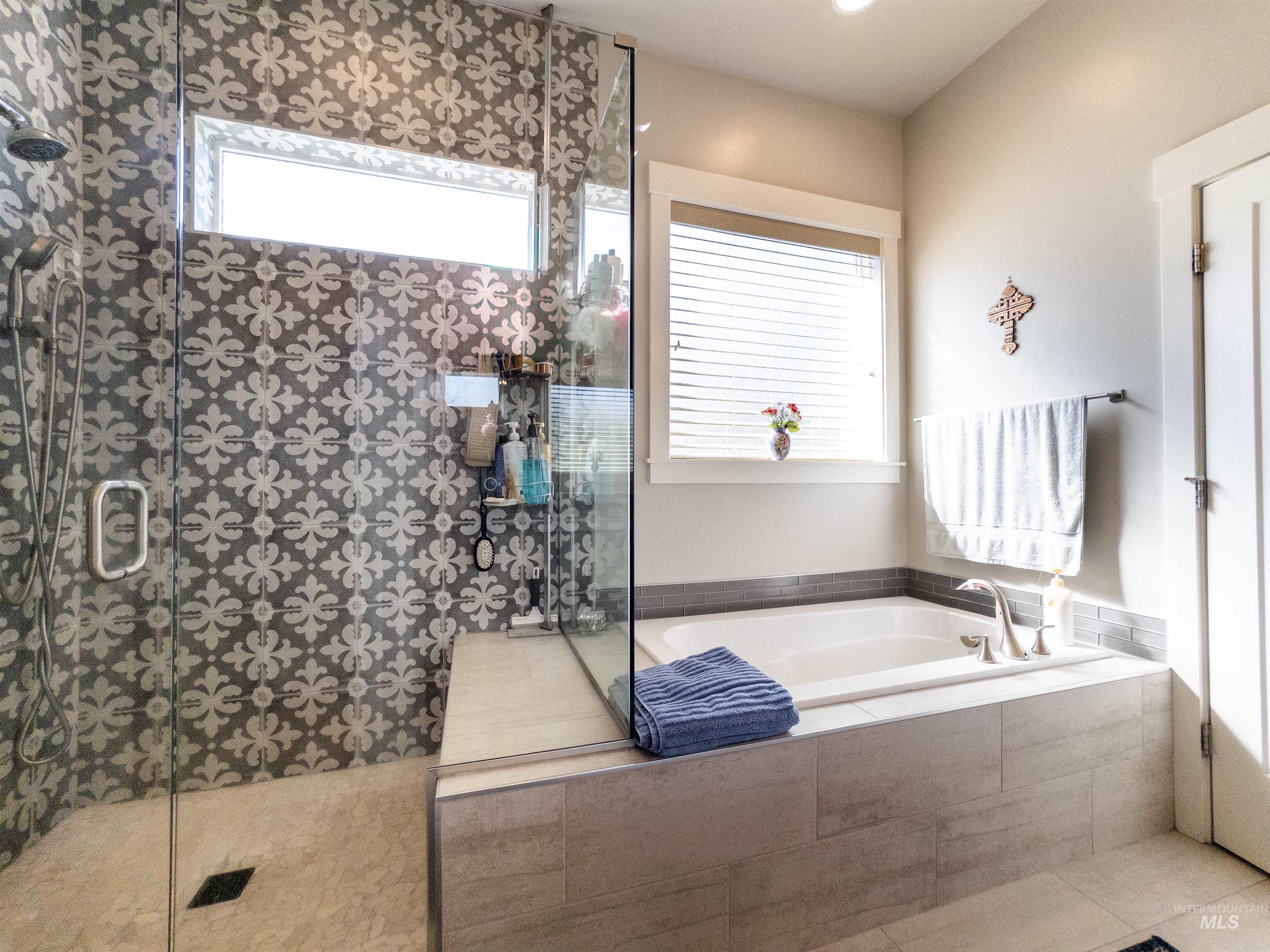 Full bathroom with walk in shower, a bath, and healthy amount of natural light