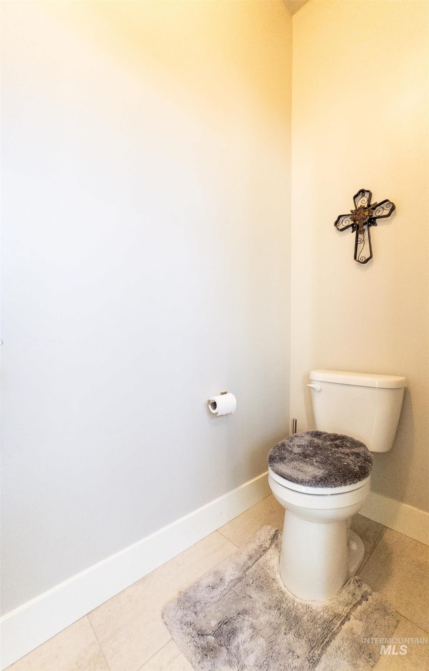 Bathroom with baseboards and light tile patterned floors