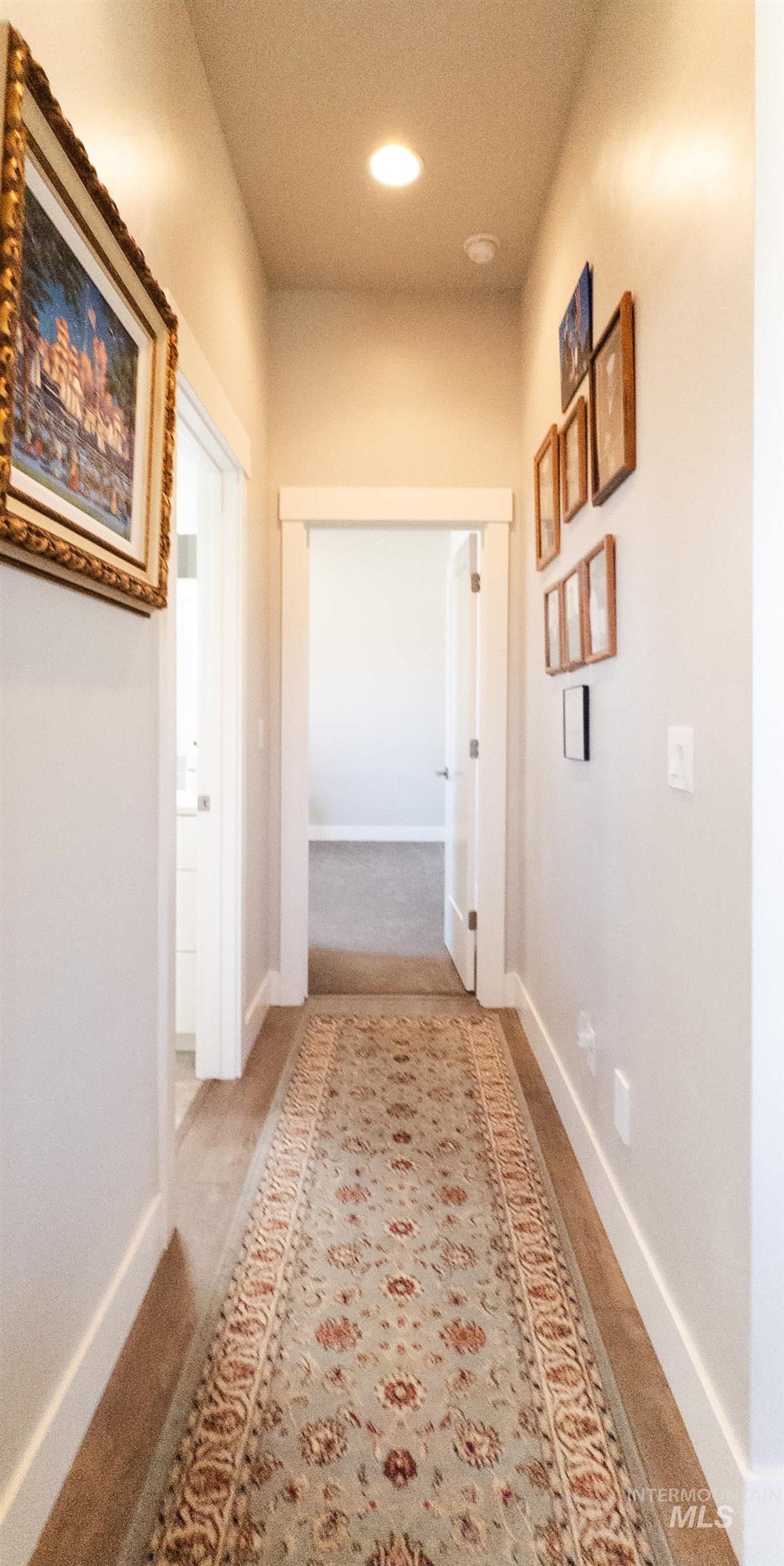 Hall with light carpet and recessed lighting