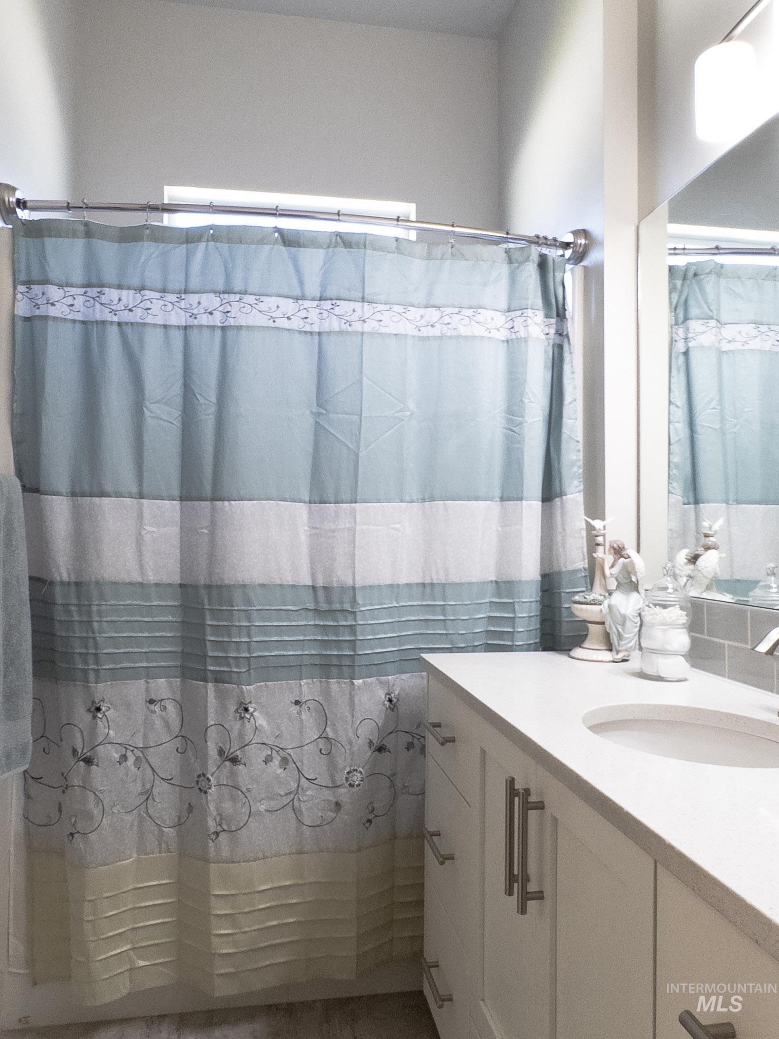 Bathroom with vanity and shower / bath combination with curtain