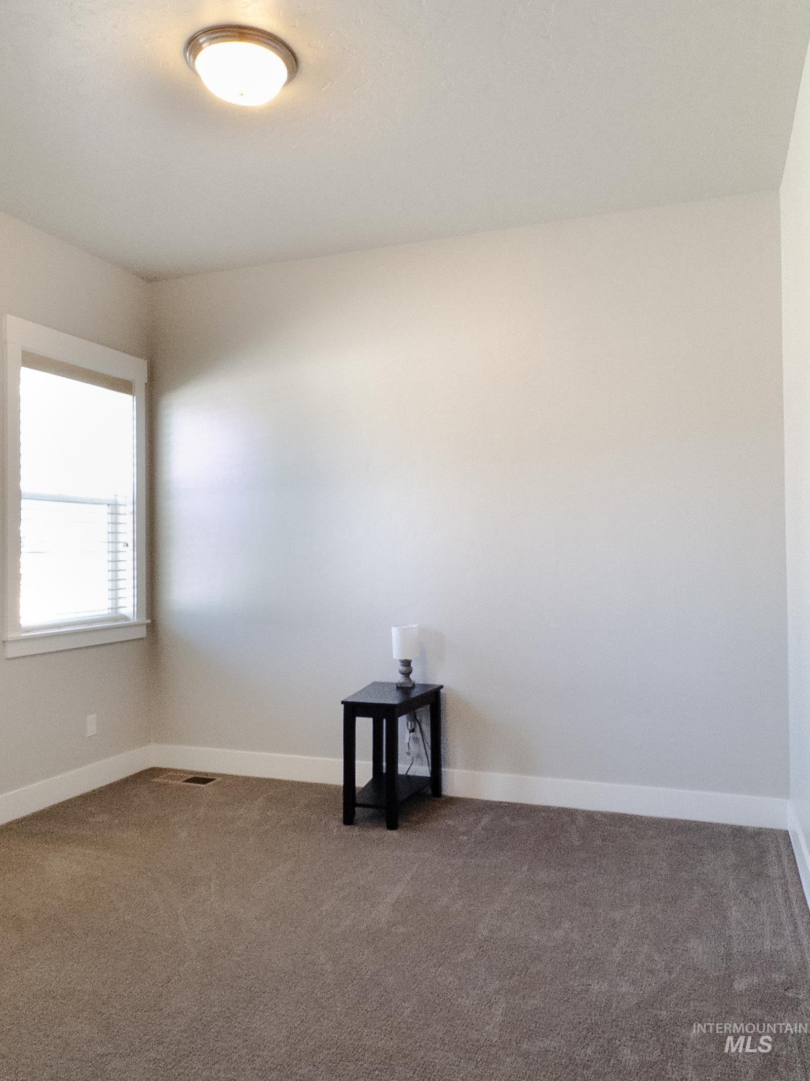 Carpeted empty room featuring baseboards