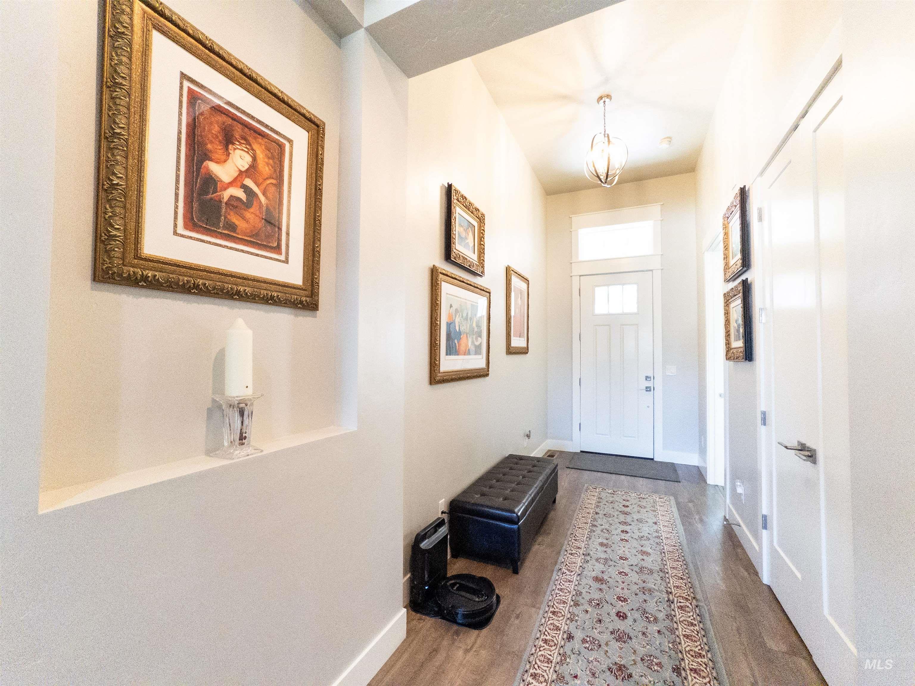 Entryway featuring wood finished floors and a chandelier